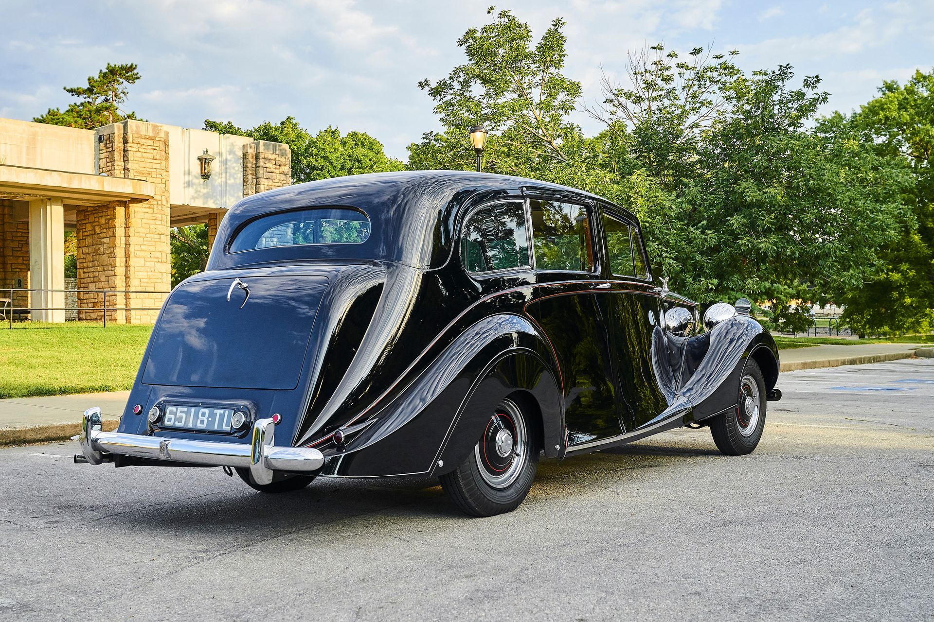 A black vintage car is parked on the side of the road.