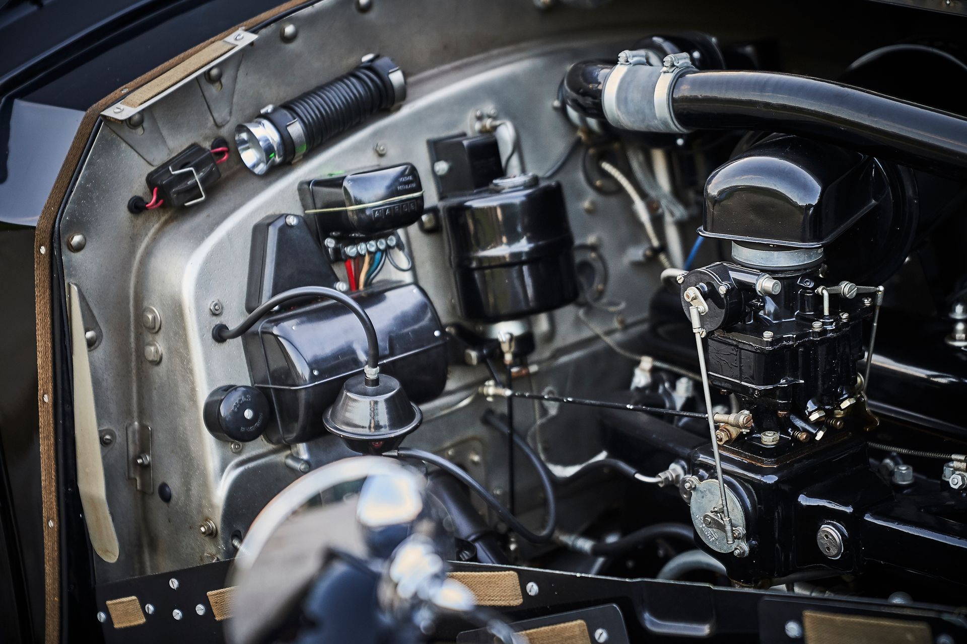 A close up of a car engine with a lot of wires coming out of it.