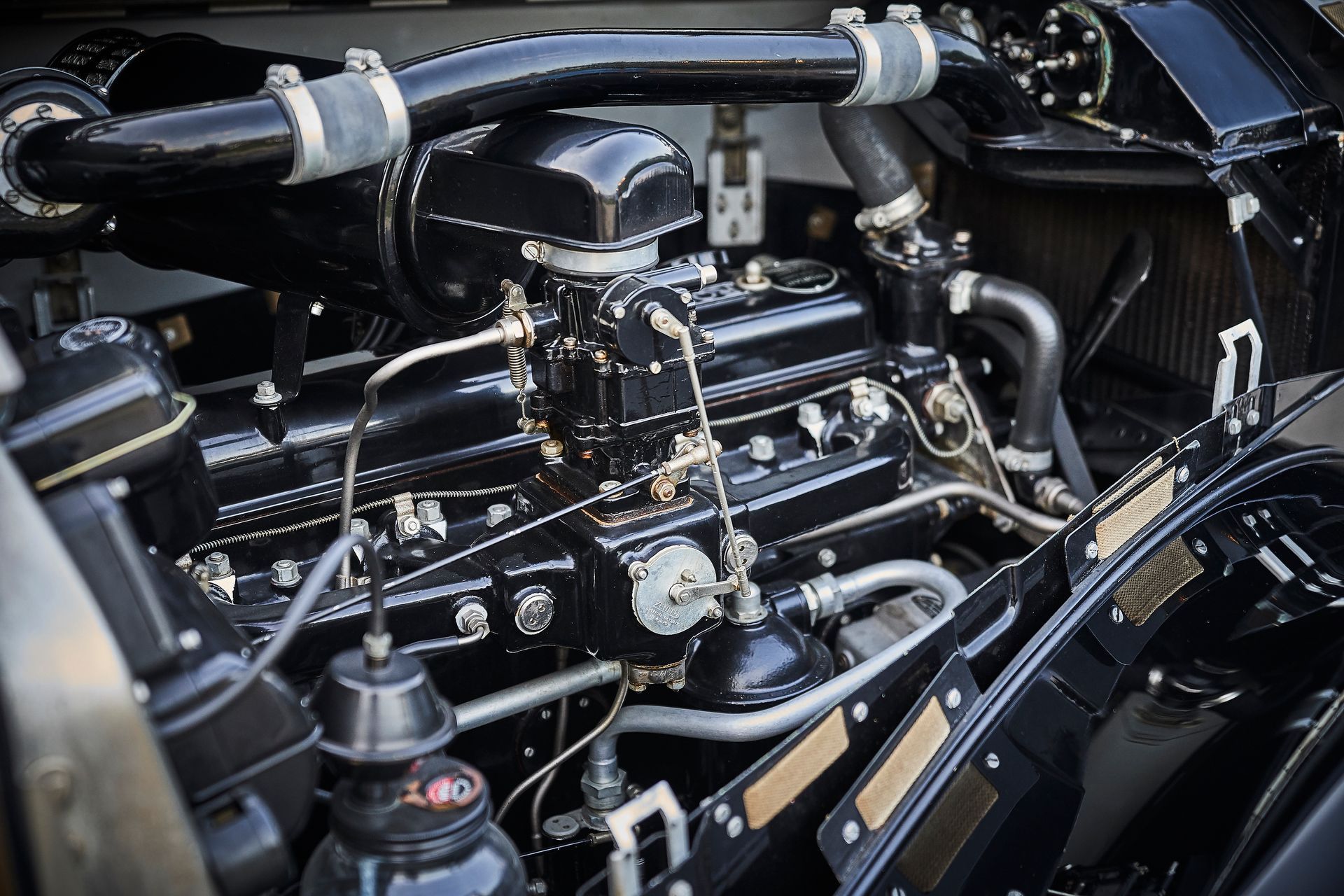 A close up of a black car engine with the hood open