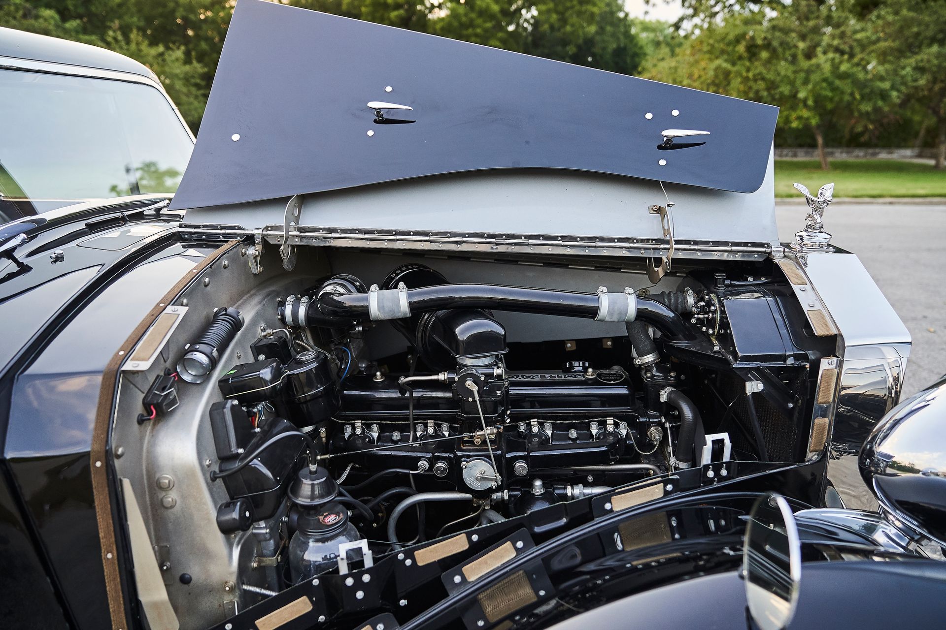 A black car with the hood open and the engine visible