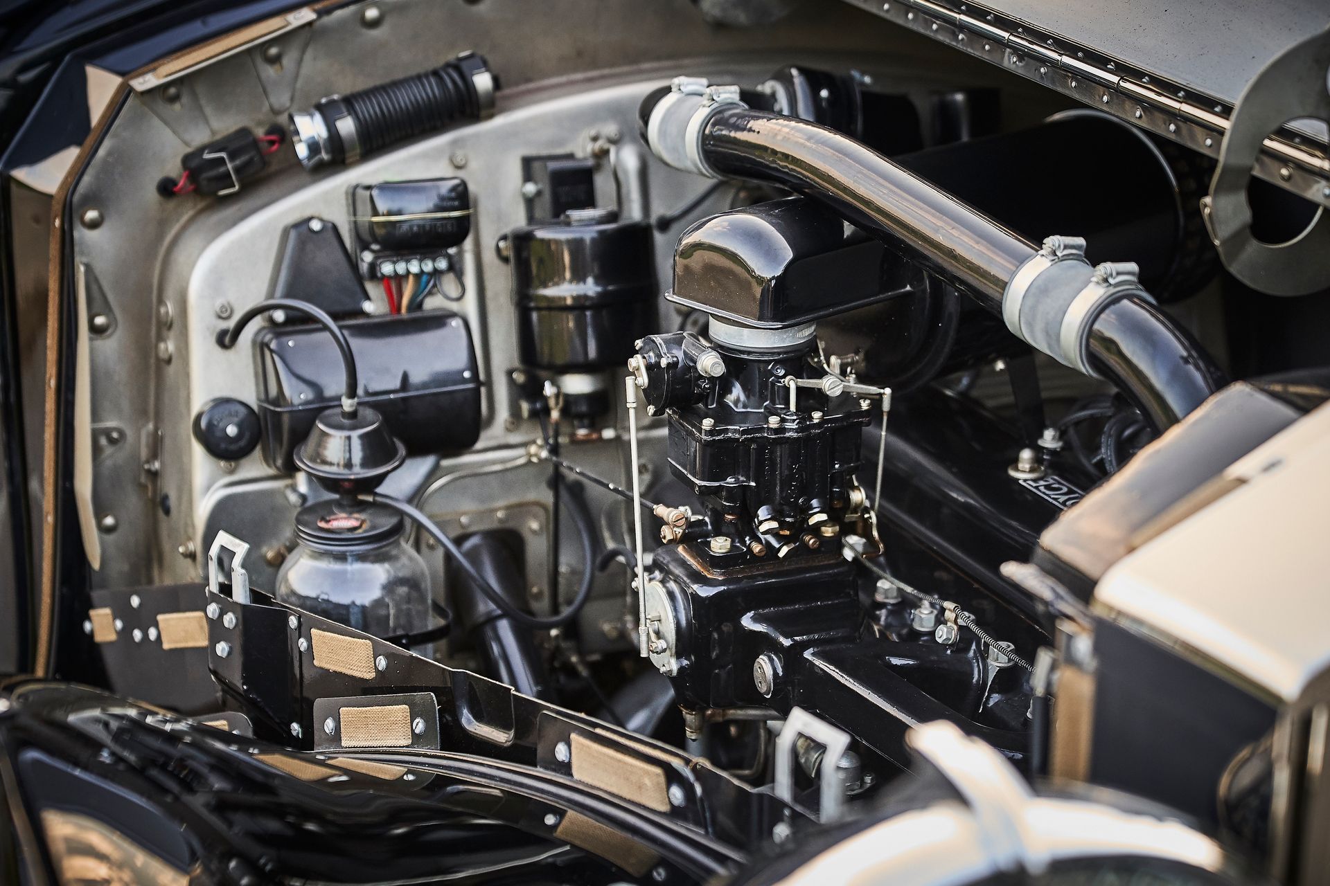 A close up of the engine of a car with the hood open.
