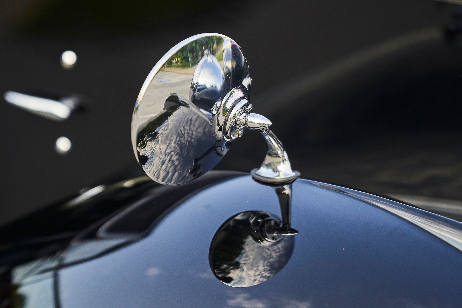 A close up of a side view mirror on the hood of a car.