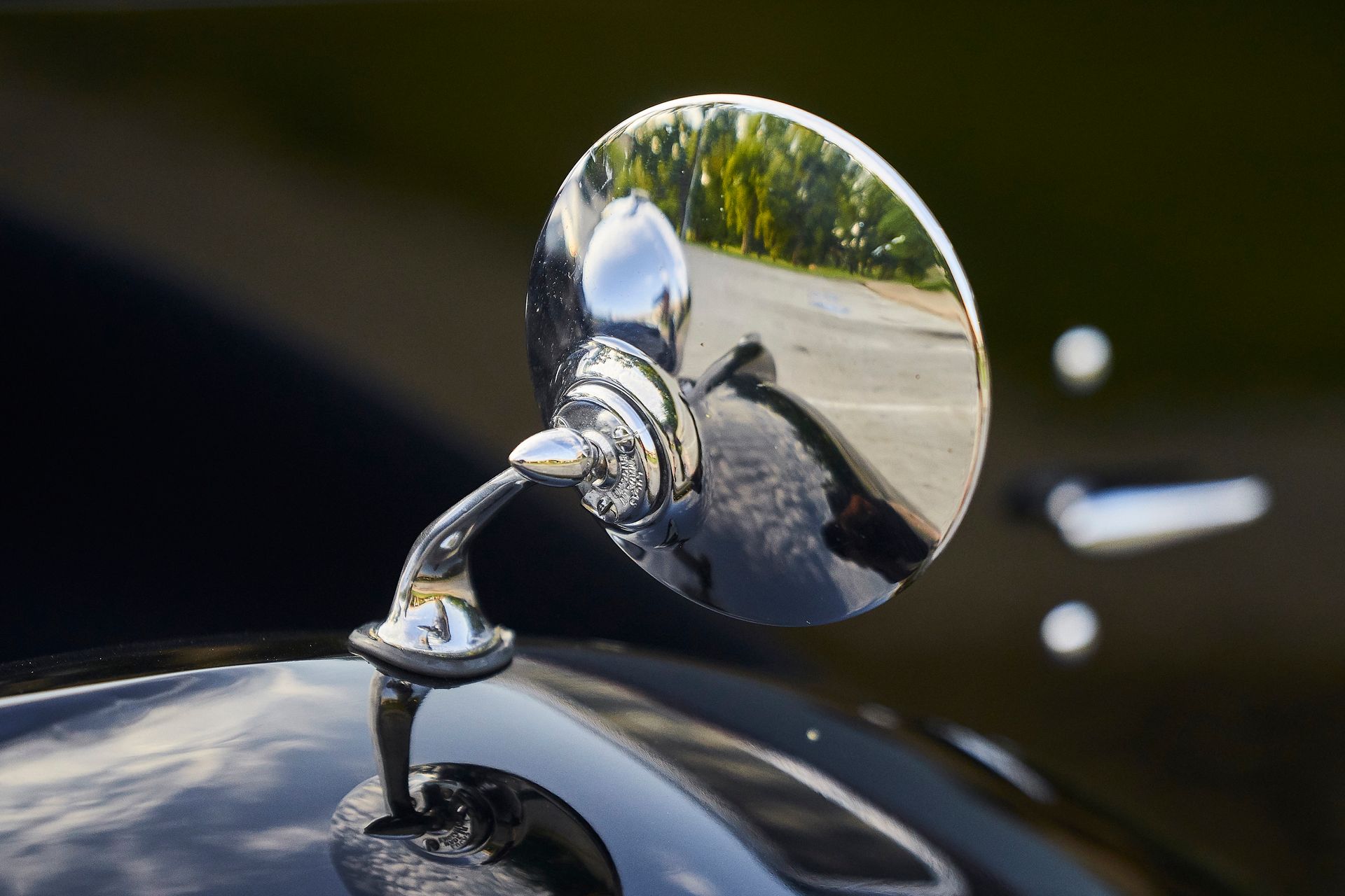 A close up of a side view mirror on a black car.