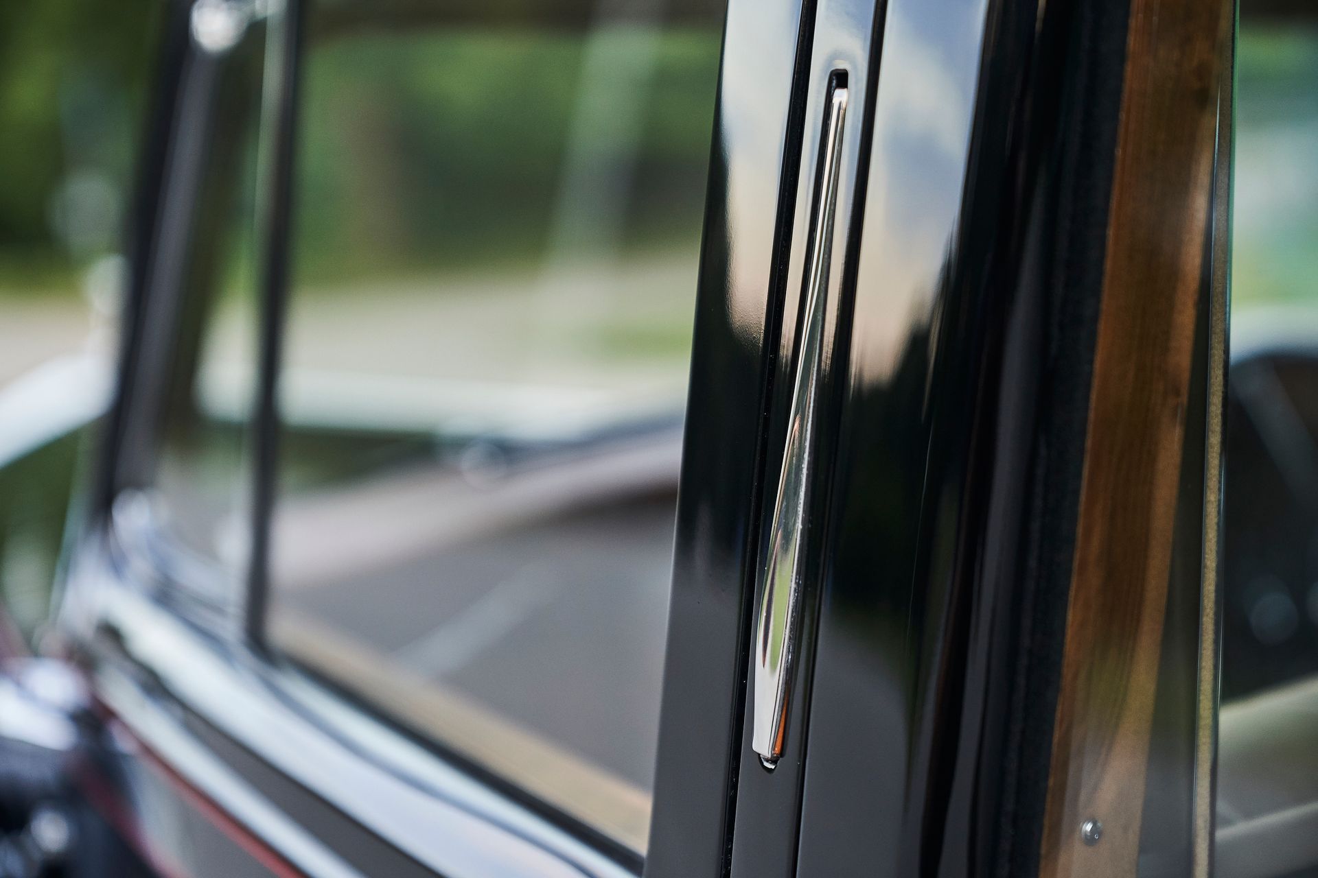 A close up of a car window with a wooden trim.