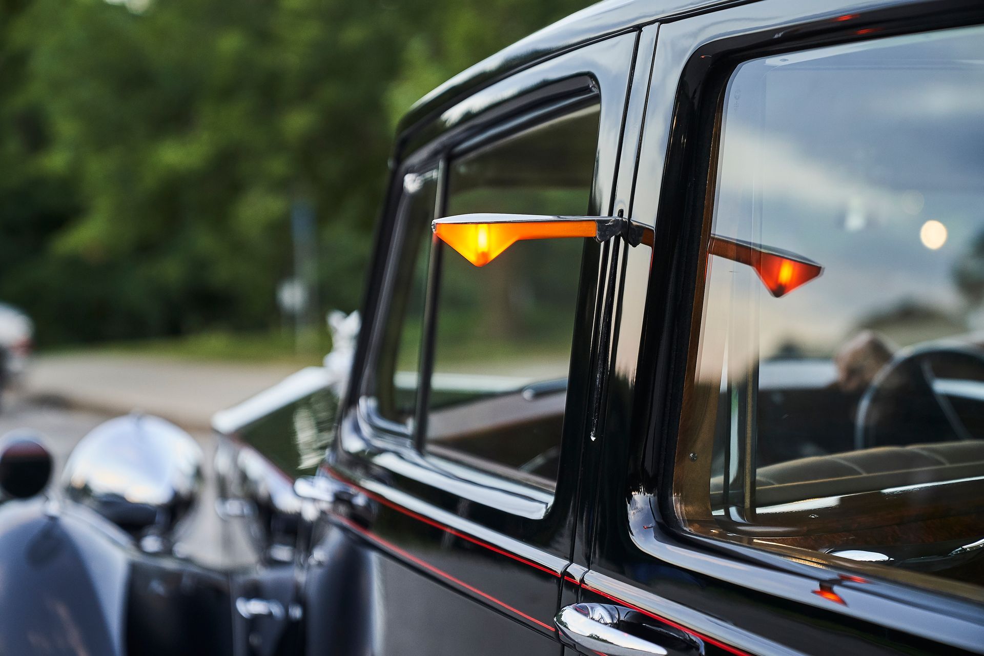 A close up of a car window with a light on it.