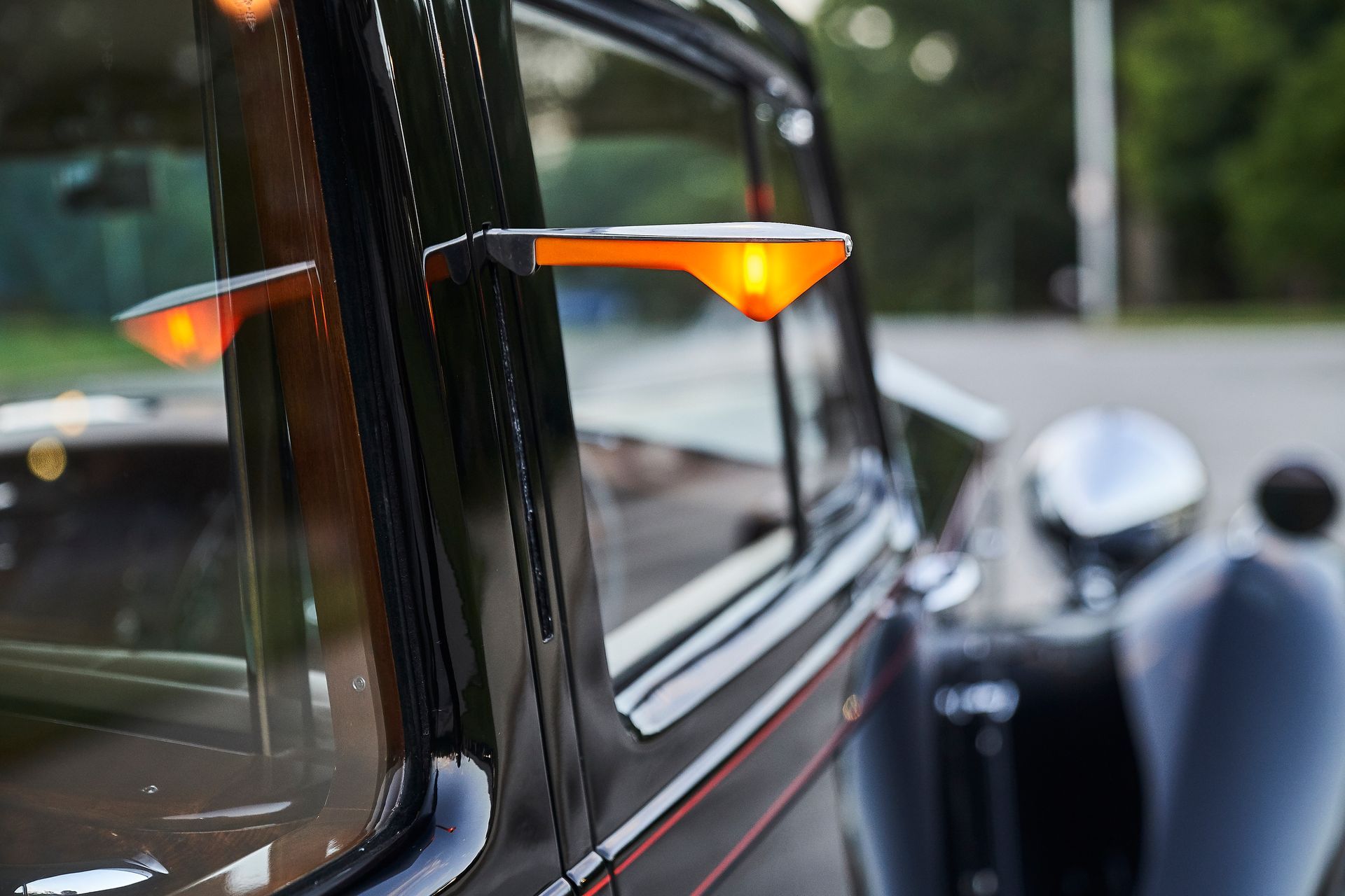 A close up of a car window with a light on it.