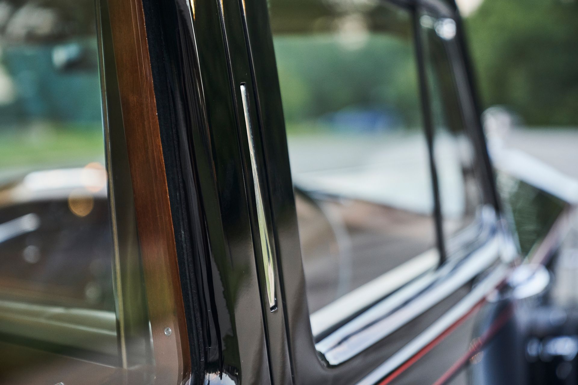 A close up of a car window with a wooden trim.