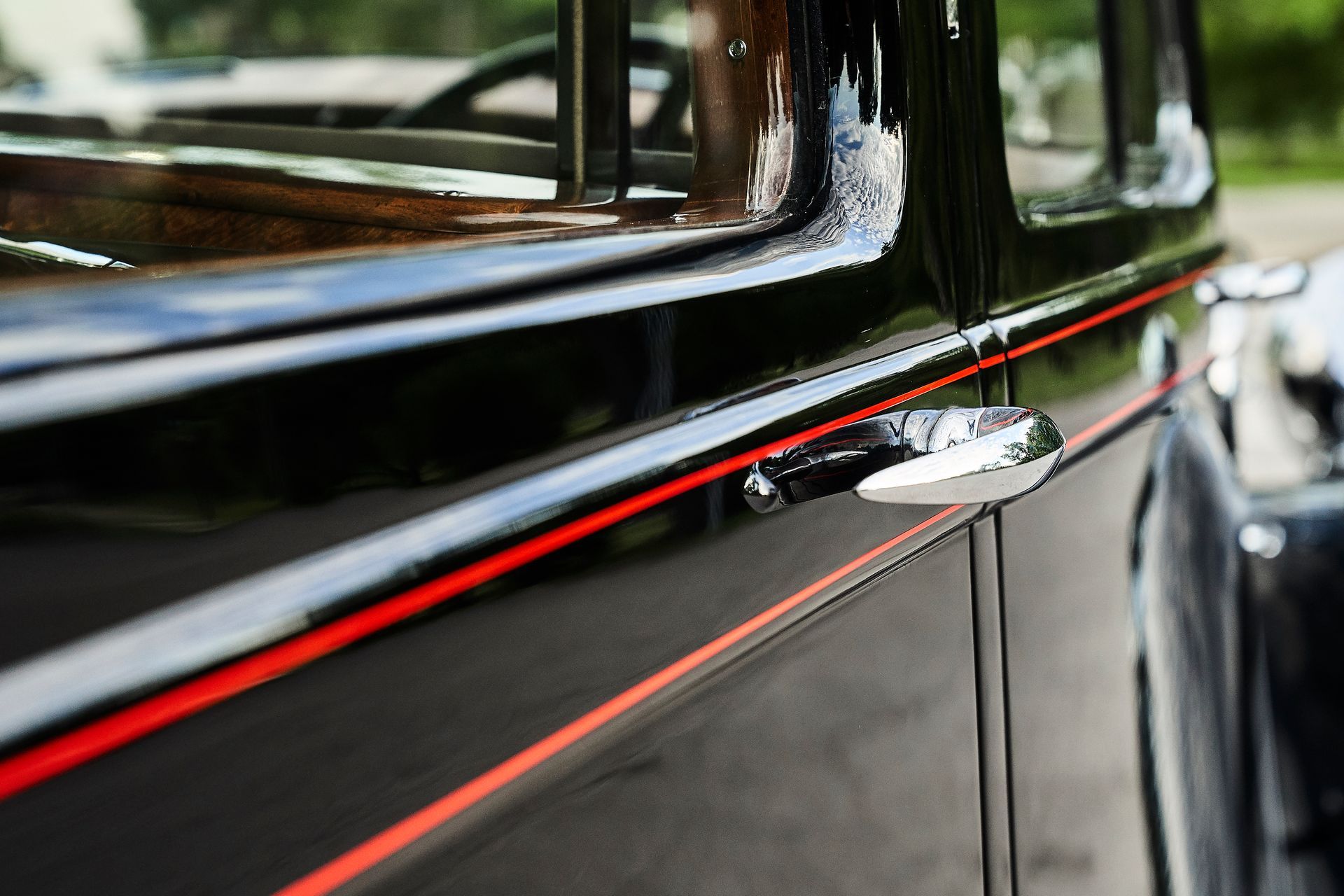 A close up of a black car with red stripes on the side
