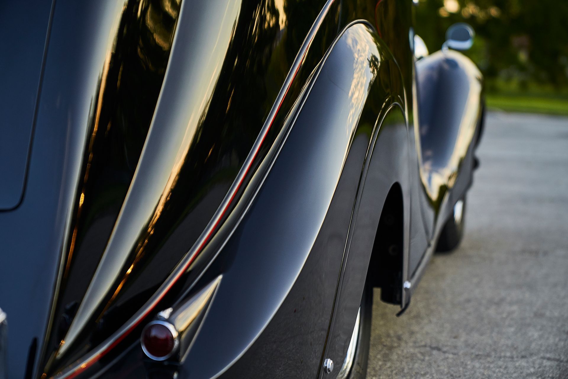 A black car is parked on the side of the road.