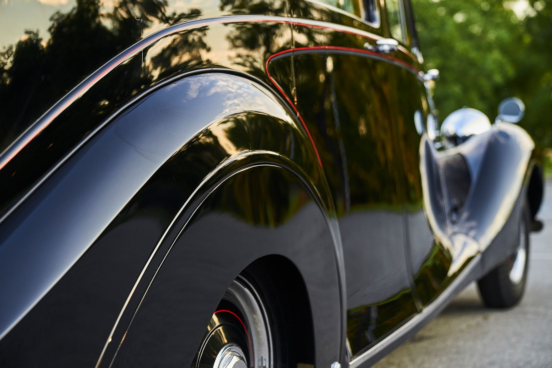 A black car is parked on the side of the road.