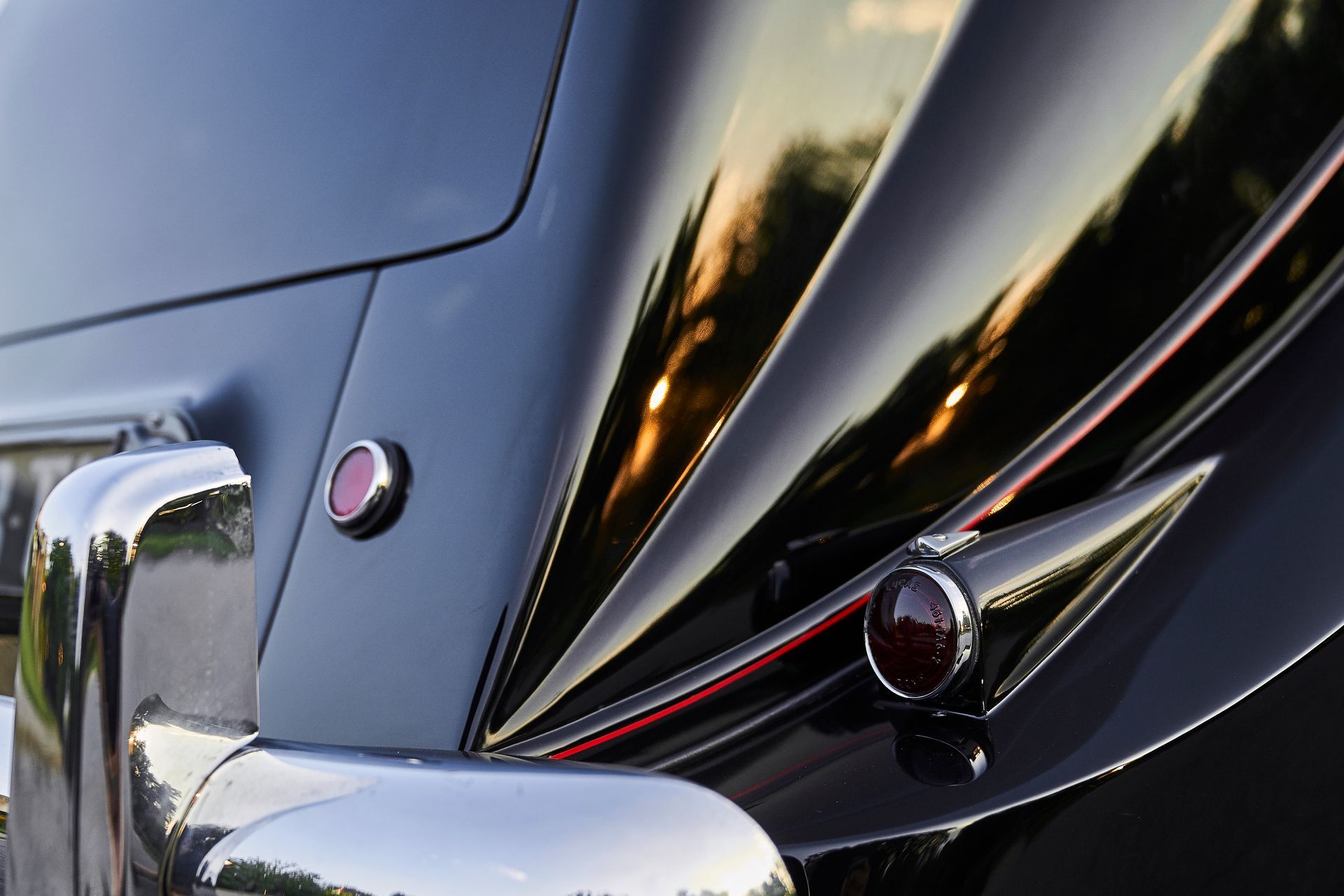 A close up of a black car with a red light