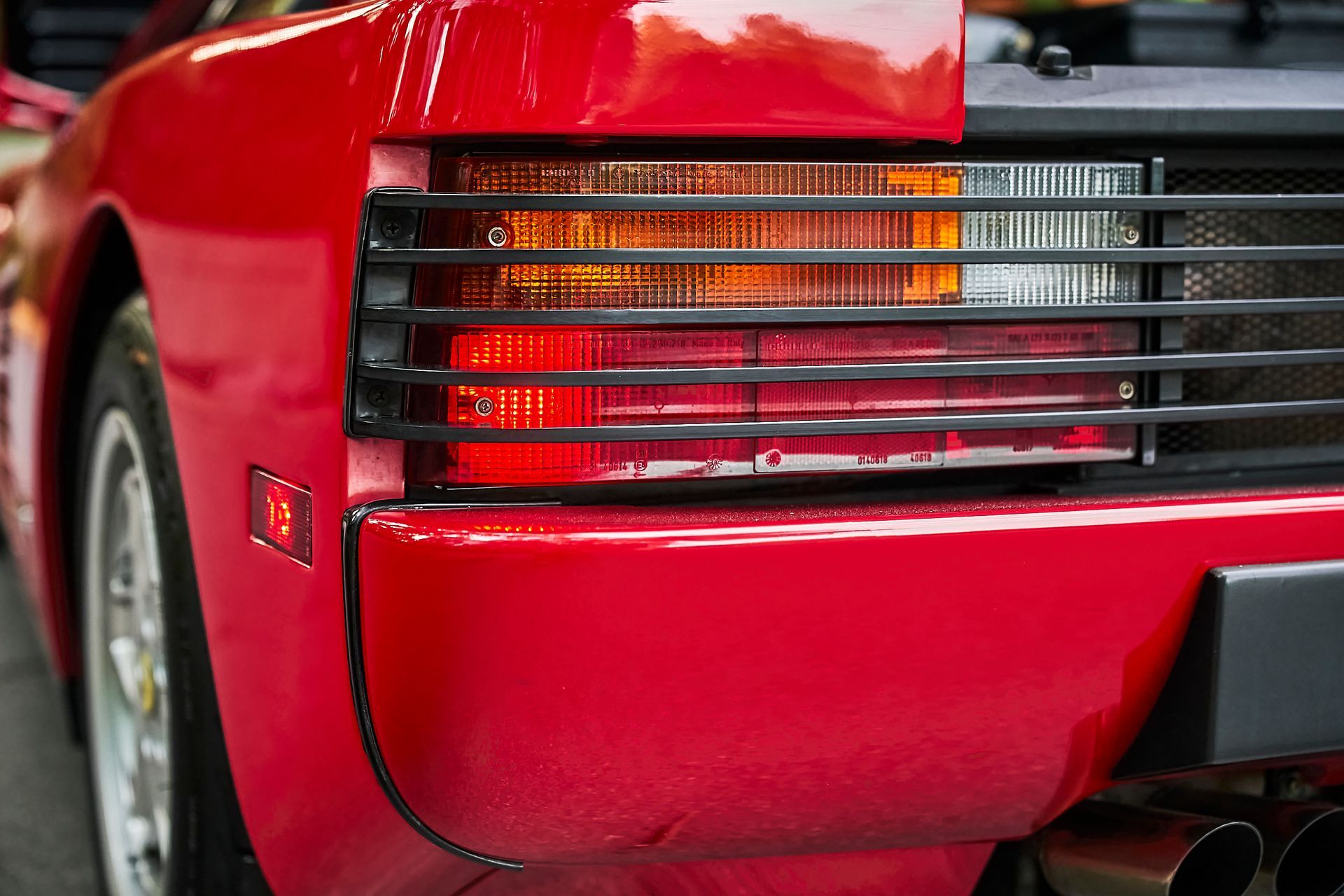 A close up of a red sports car 's tail light.