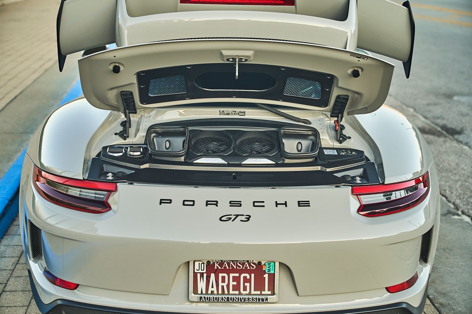 A white porsche gt3 with the trunk open