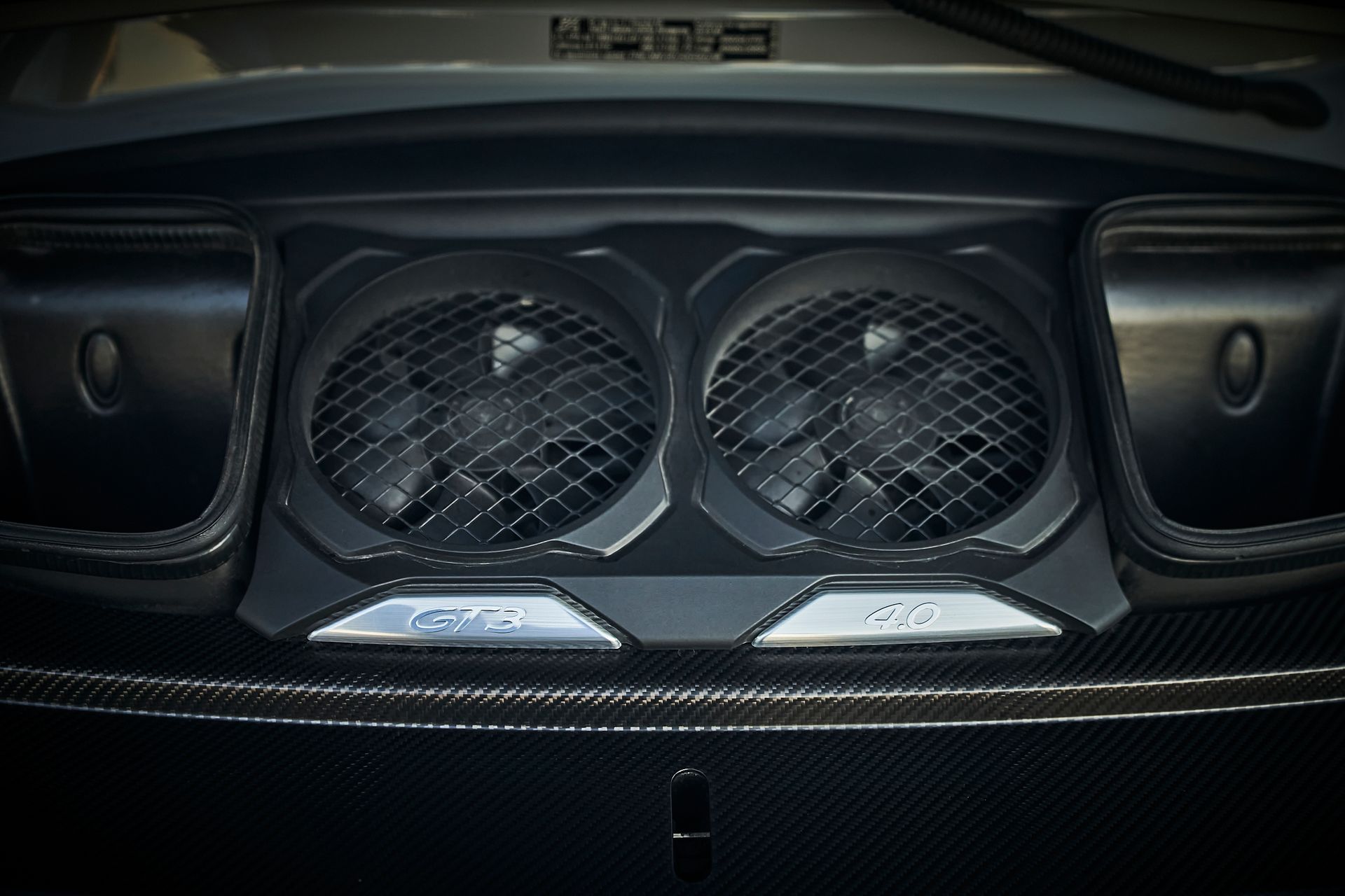 A close up of the hood of a car with two fans on it