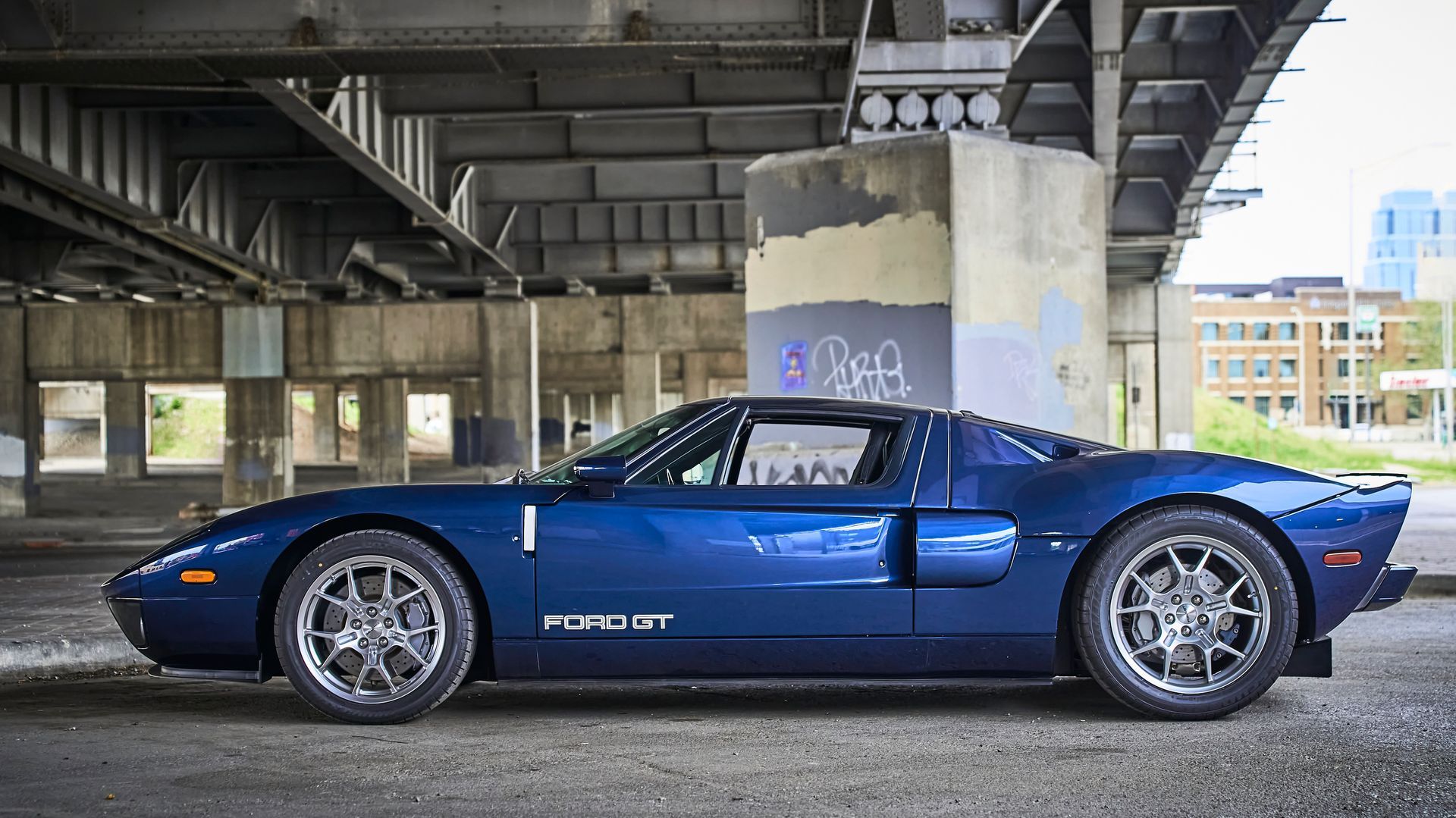 2006 Ford GT -A blue sports car is parked under a bridge.