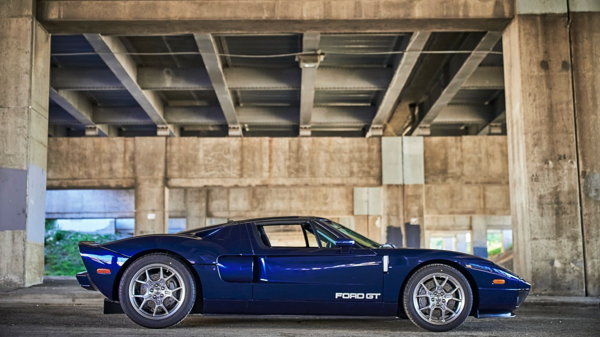2006 Ford GT -A blue sports car is parked under a bridge.