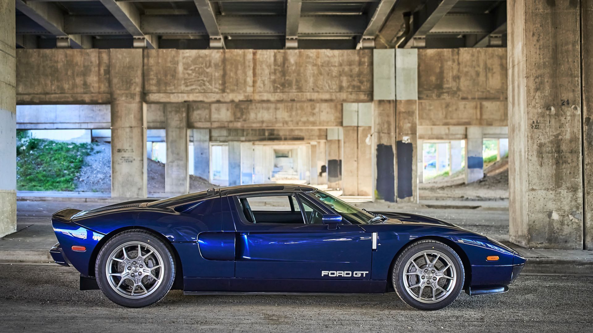 2006 Ford GT -A blue ford gt is parked under a bridge in a garage.