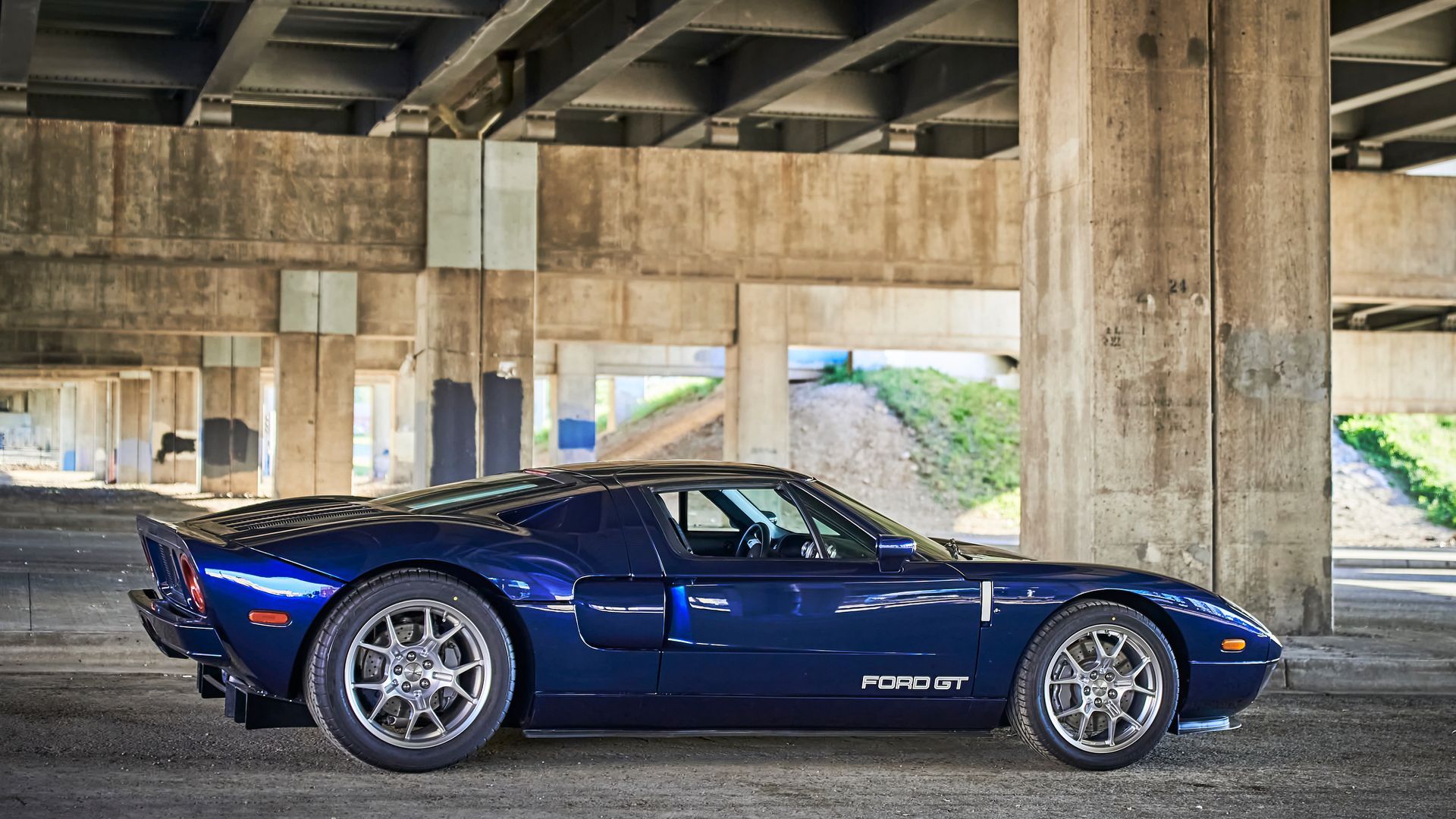 2006 Ford GT -A blue sports car is parked under a bridge.
