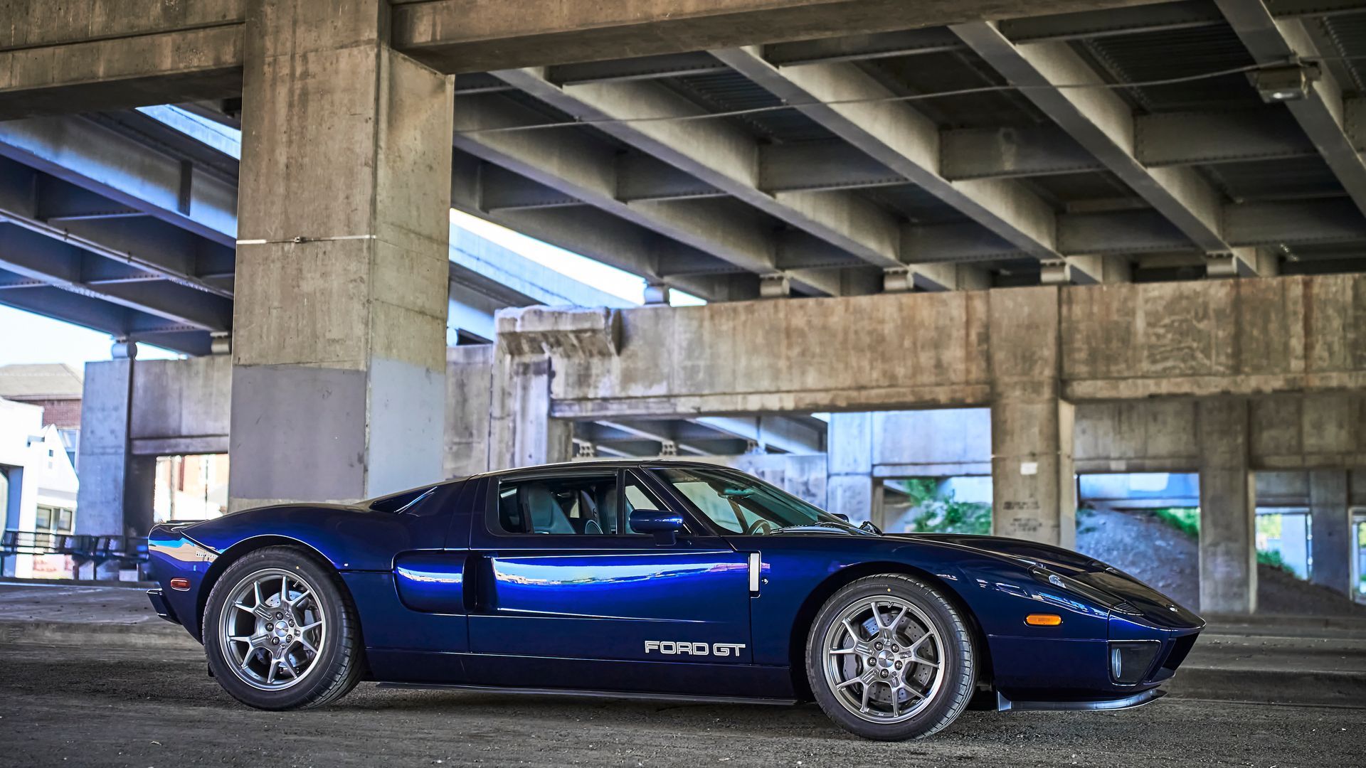 2006 Ford GT -A blue sports car is parked under a bridge.