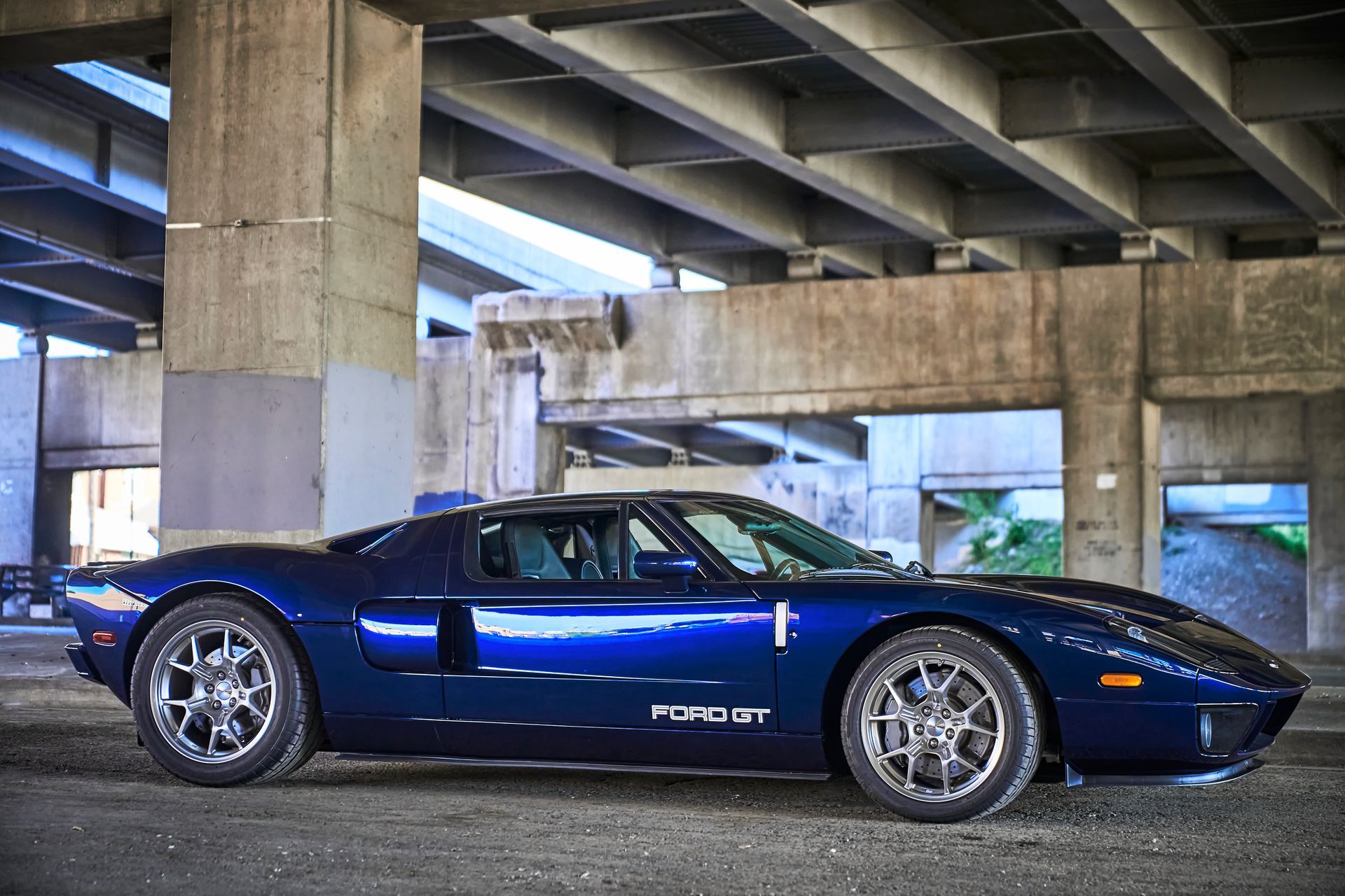 2006 Ford GT -A blue sports car is parked under a bridge.