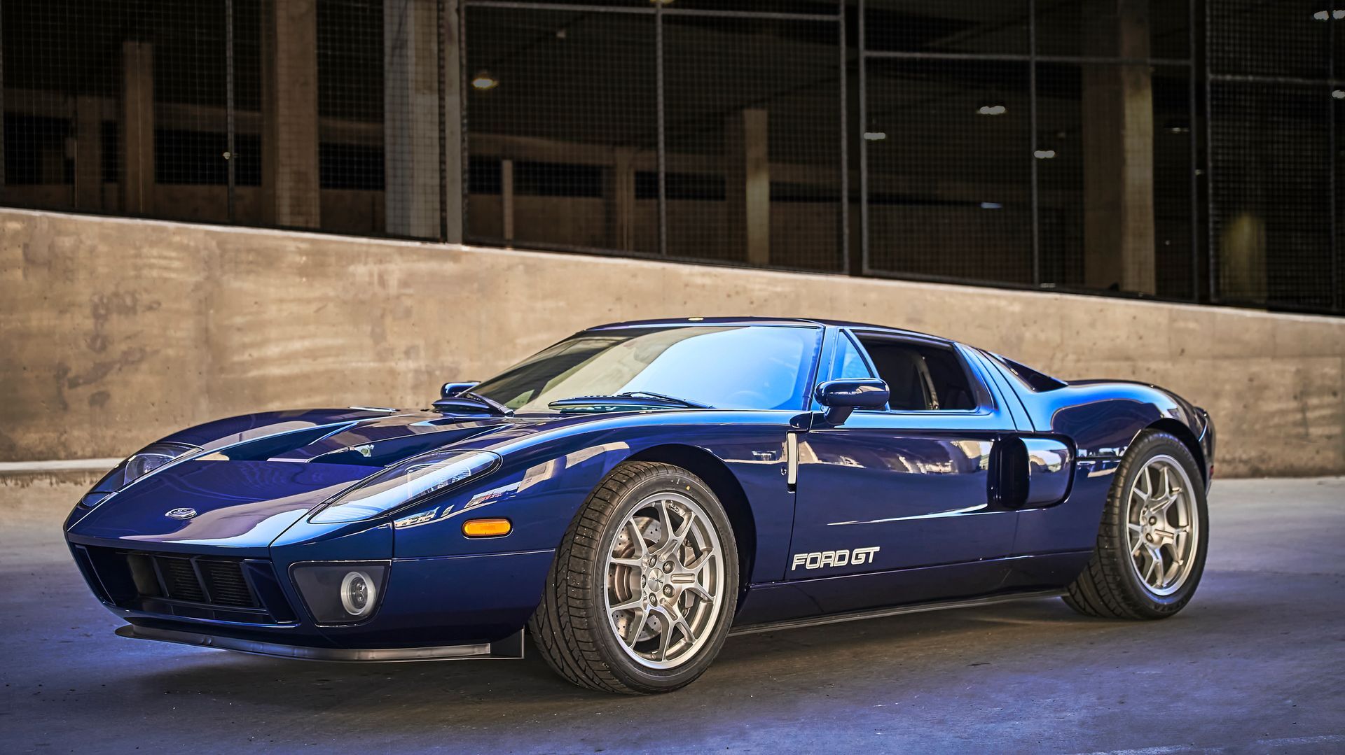 2006 Ford GT -A blue sports car is parked in front of a building.