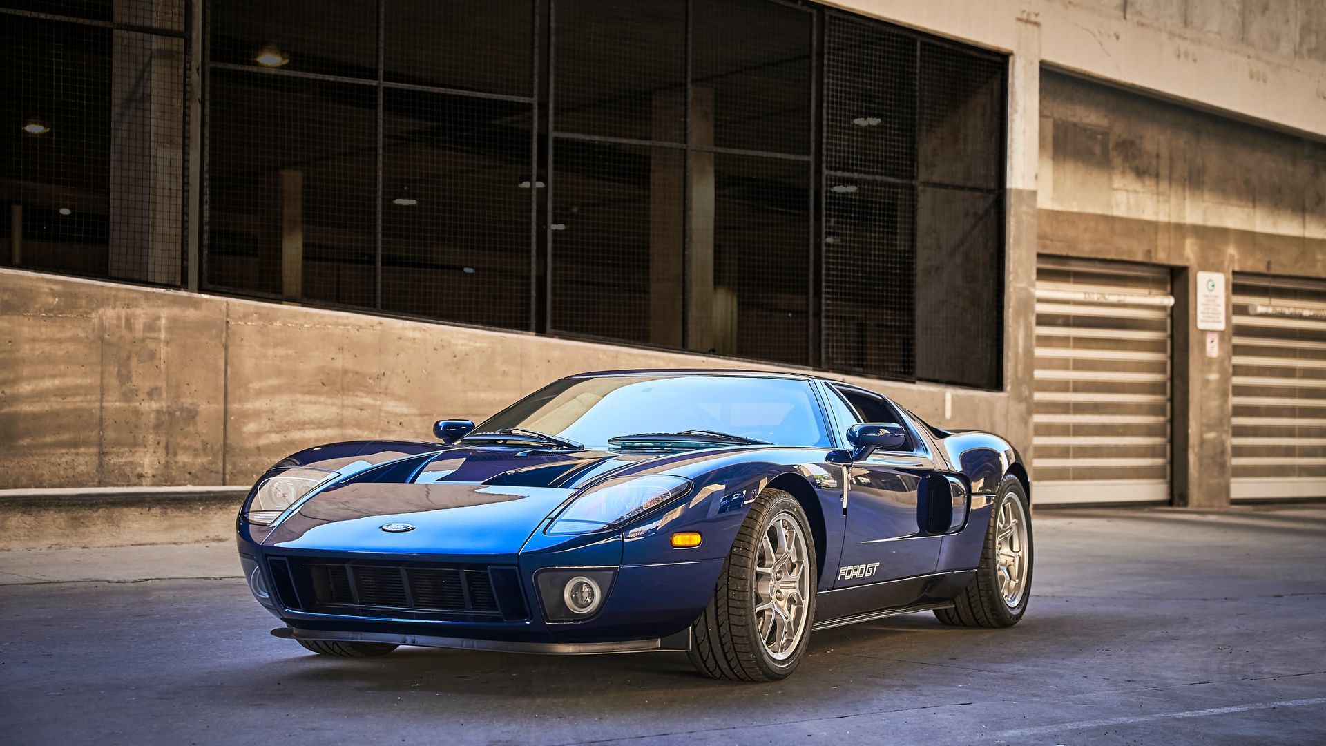 2006 Ford GT -A blue sports car is parked in front of a building.
