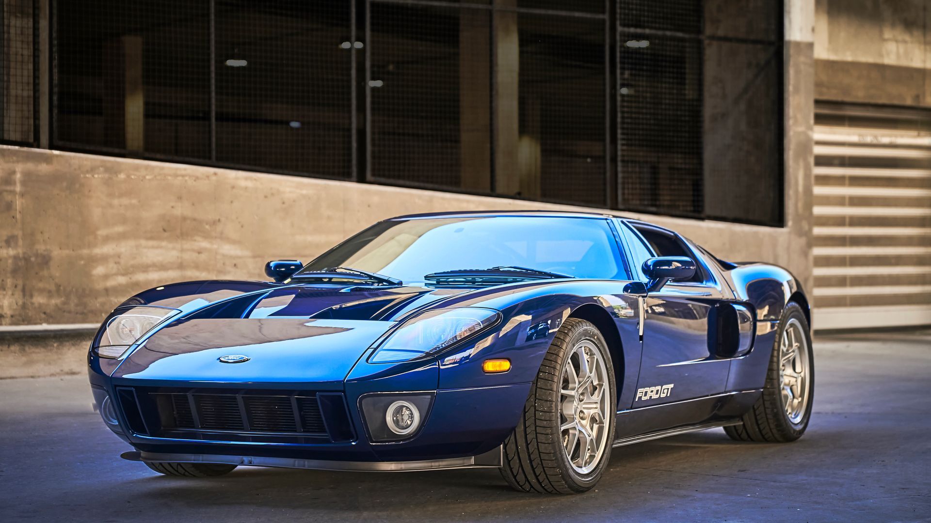 2006 Ford GT -A blue sports car is parked in front of a building.