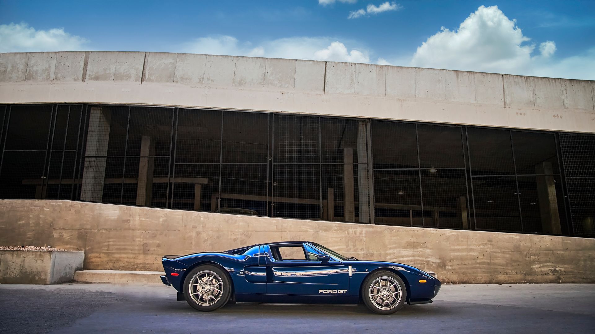 2006 Ford GT -A blue sports car is parked in front of a building.