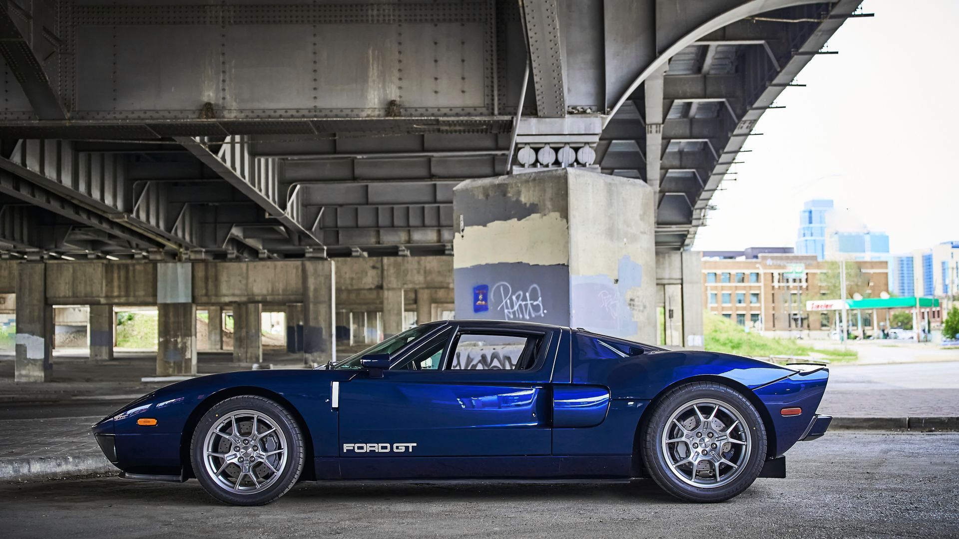 2006 Ford GT -A blue sports car is parked under a bridge.