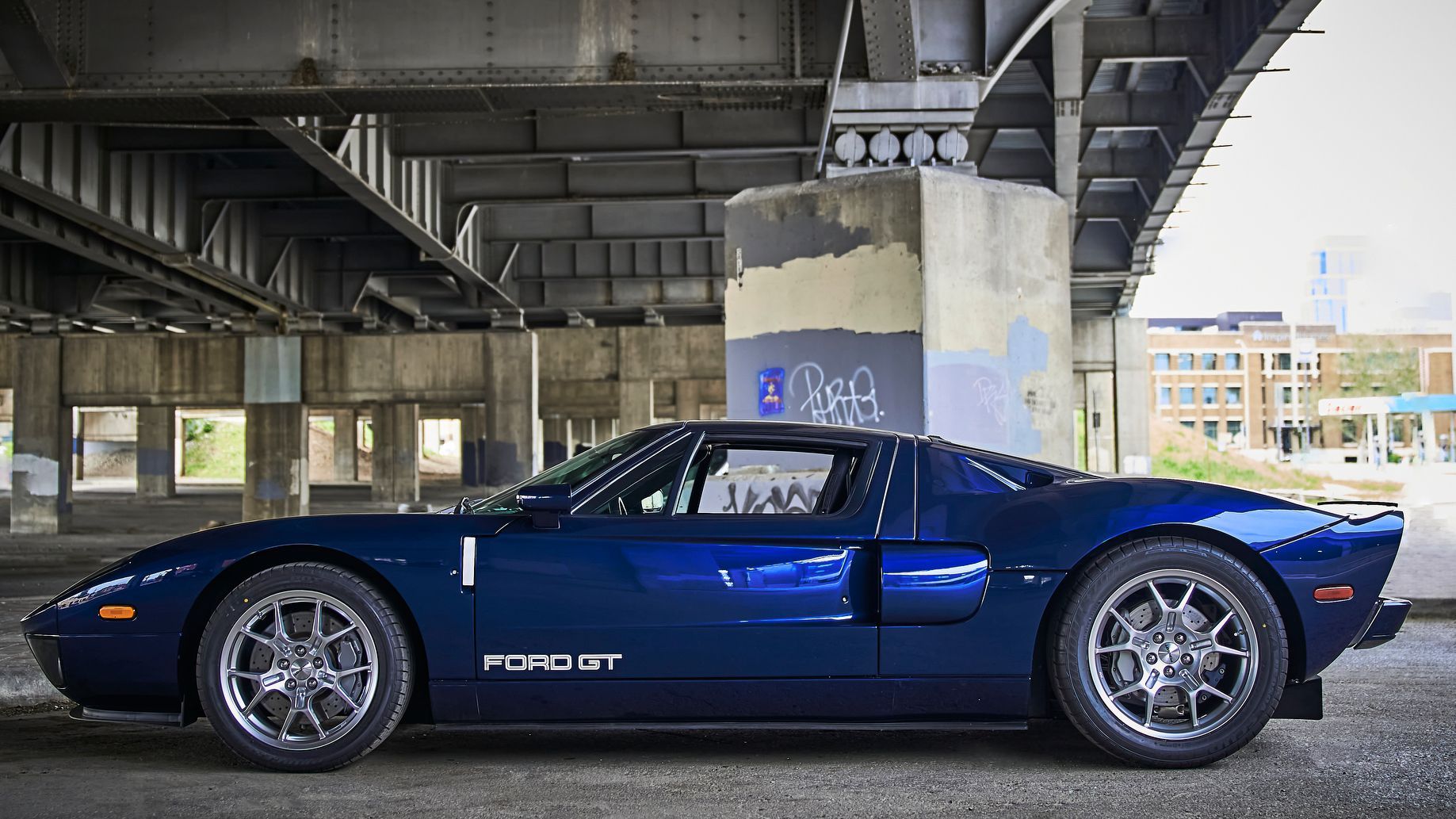 2006 Ford GT -A blue ford gt is parked under a bridge.