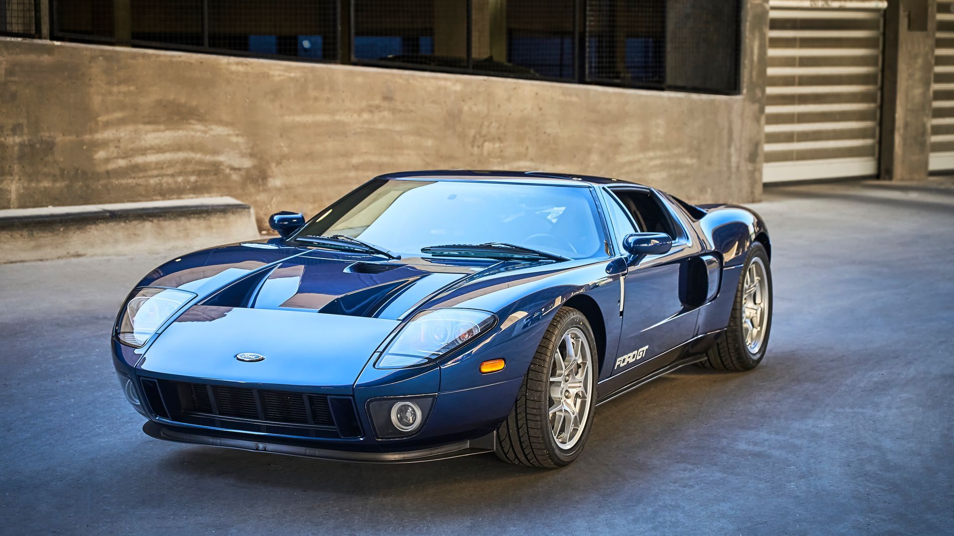 2006 Ford GT -A blue sports car is parked in front of a building.