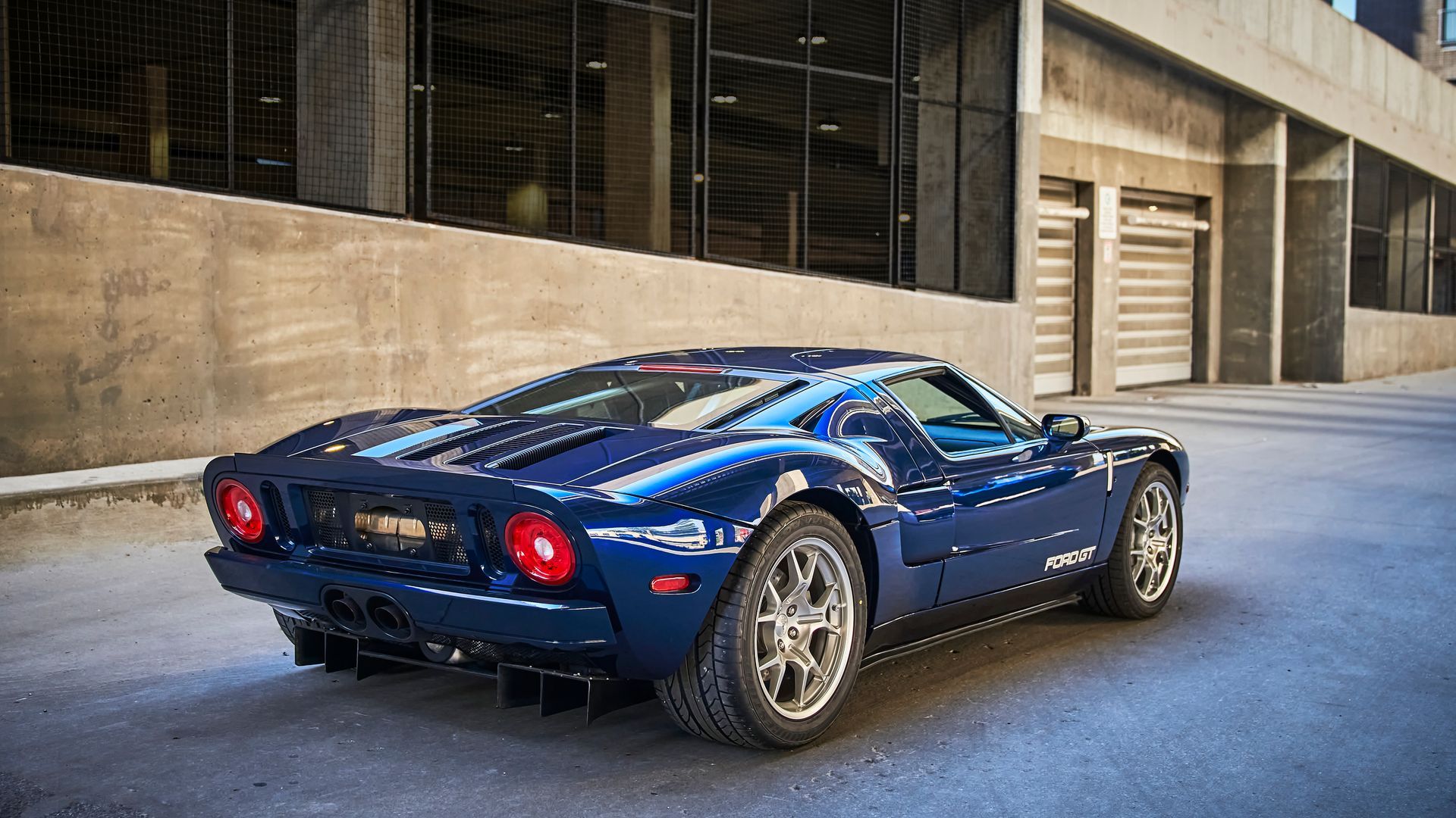 2006 Ford GT -A blue sports car is parked in front of a building.