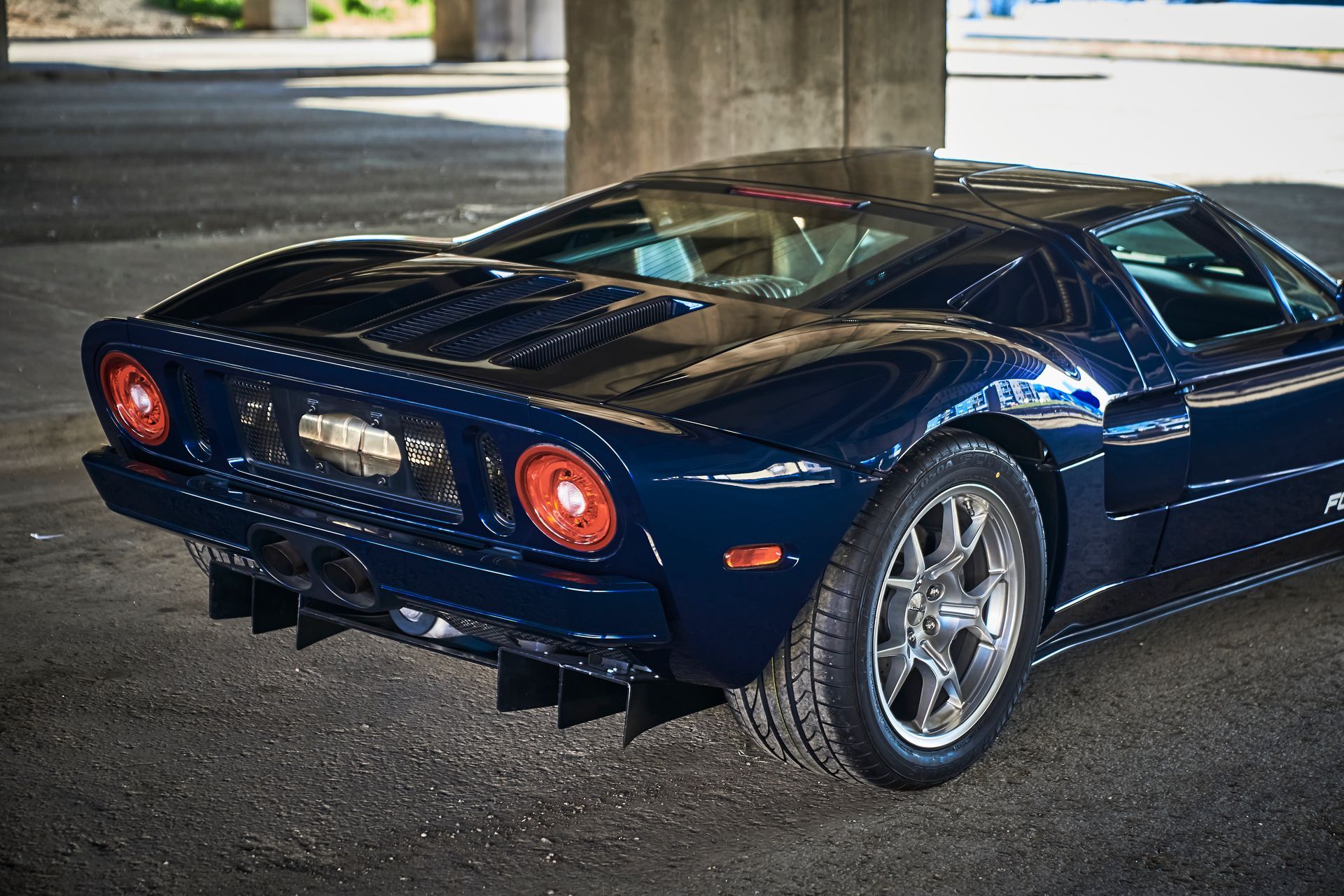 2006 Ford GT -A blue sports car is parked under a bridge.