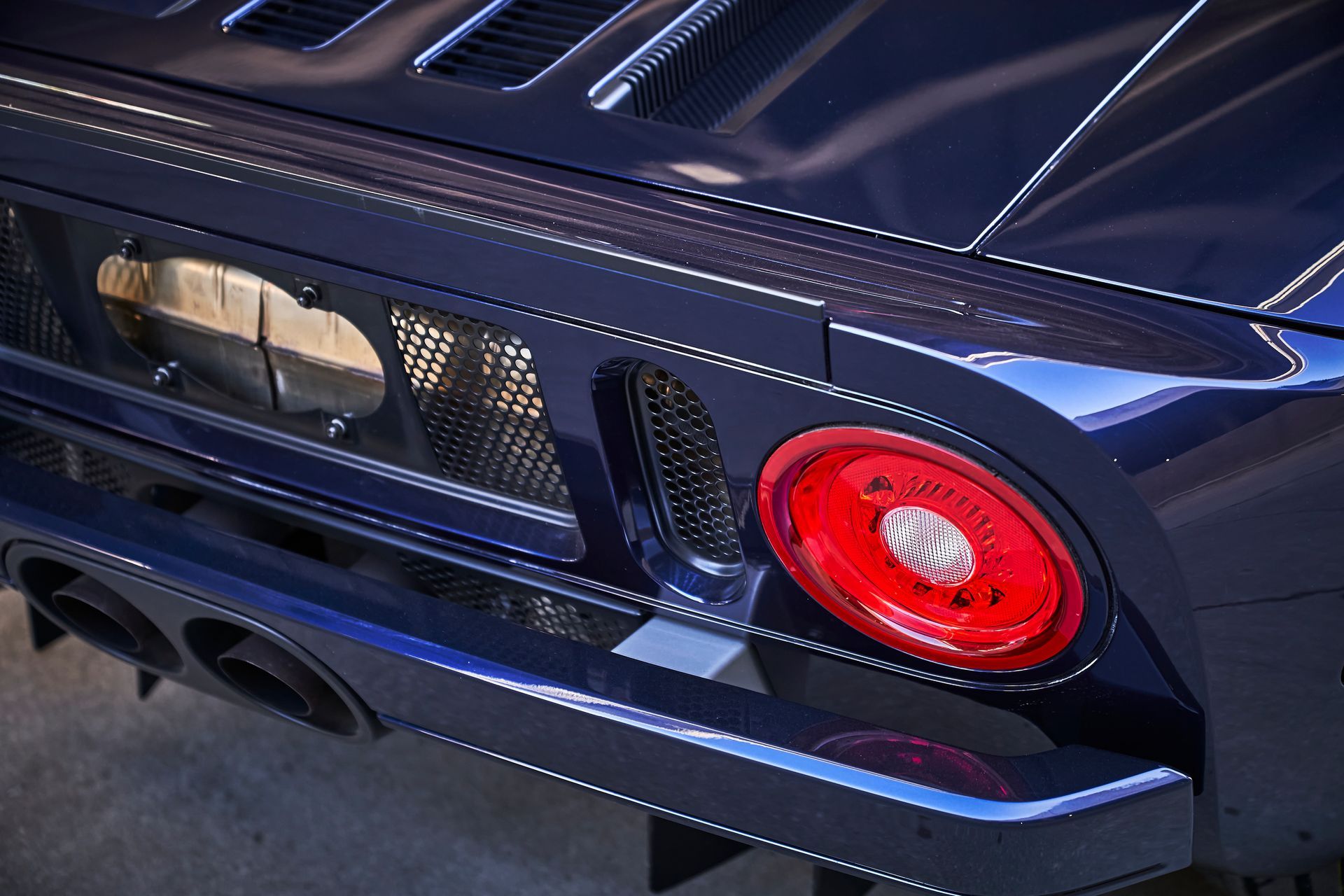 2006 Ford GT -The rear end of a blue sports car with a red tail light.