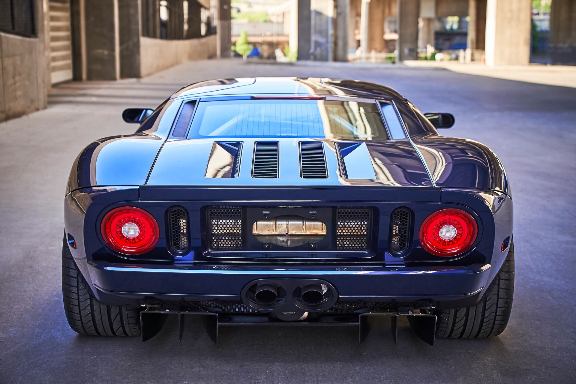 2006 Ford GT -A blue sports car is parked in a parking lot in front of a building.