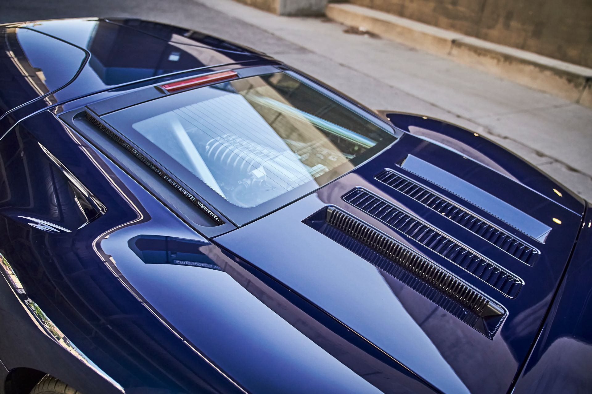 A close up of the hood of a blue sports car