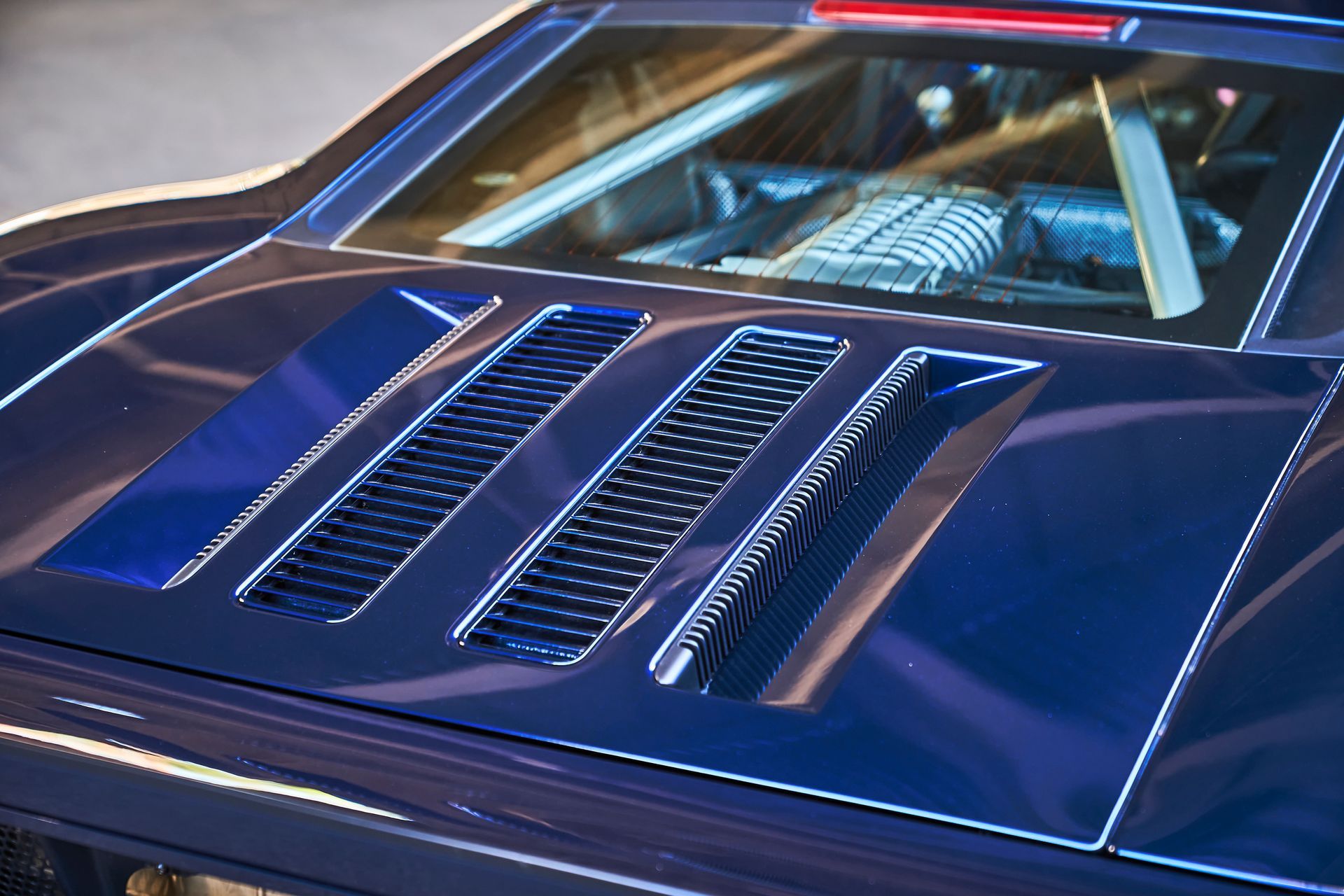 A close up of the hood of a blue sports car