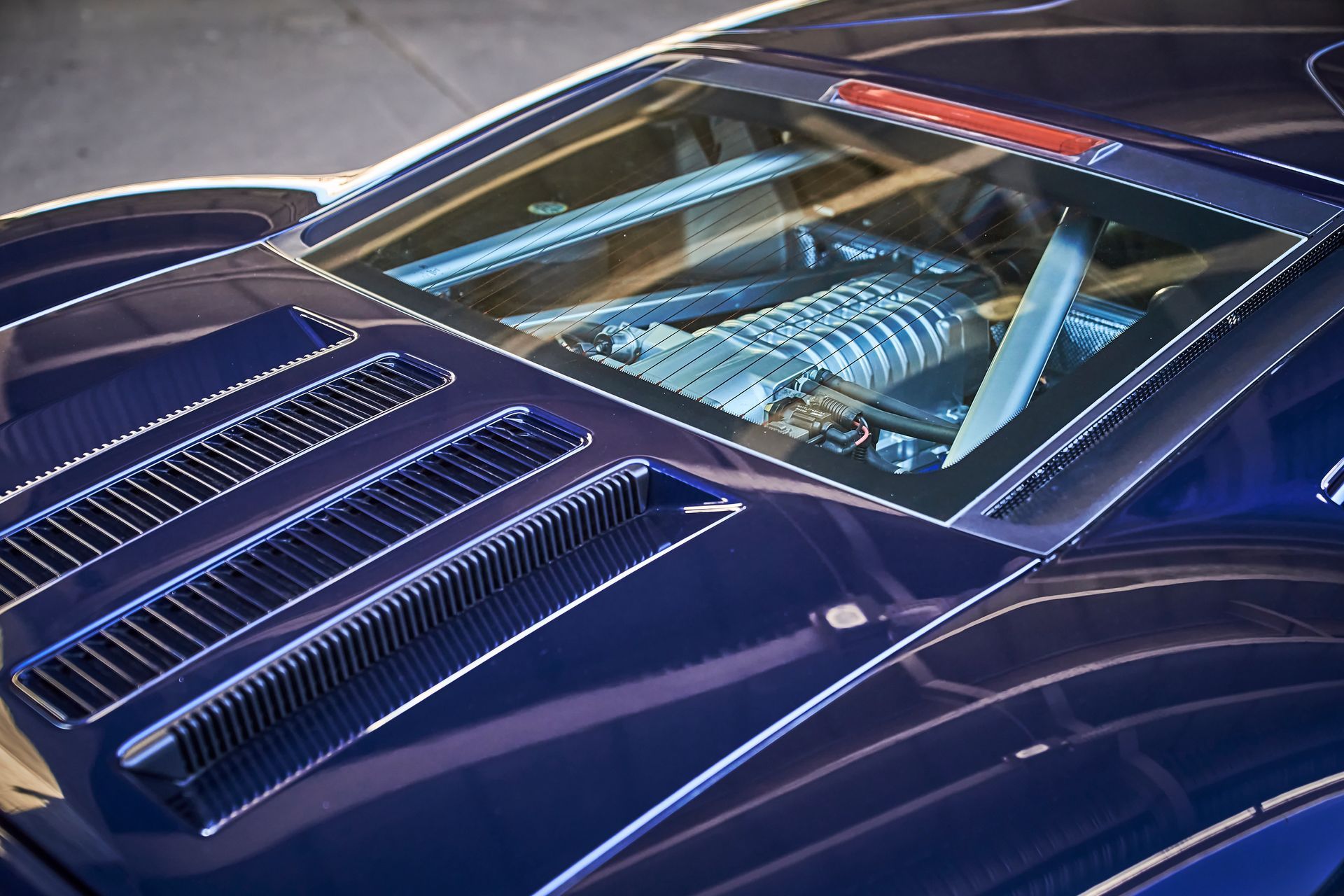A close up of the hood of a blue sports car.