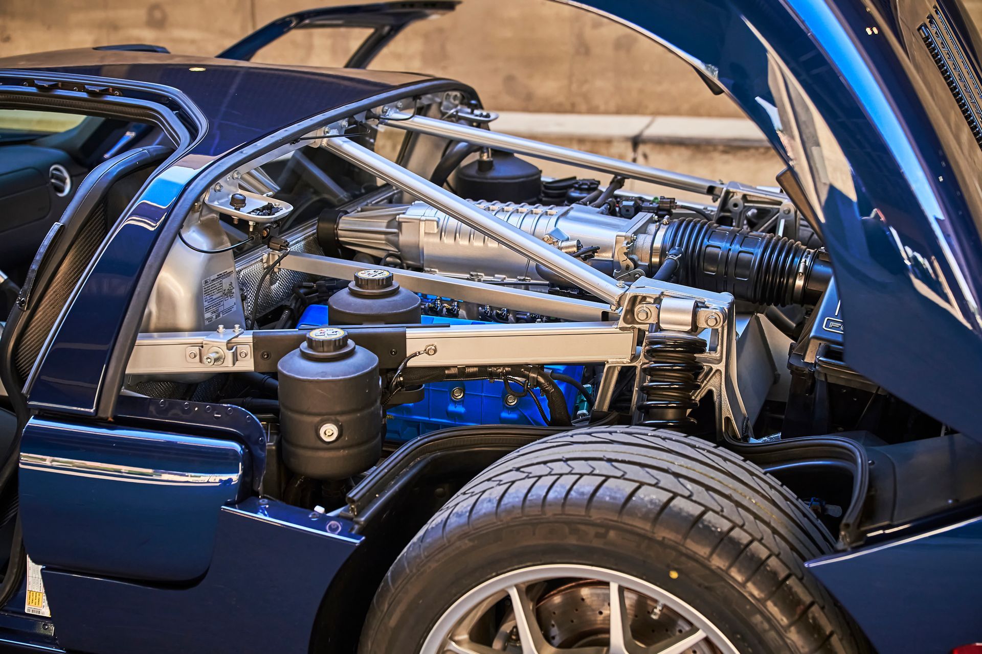 The engine of a blue sports car with the hood open