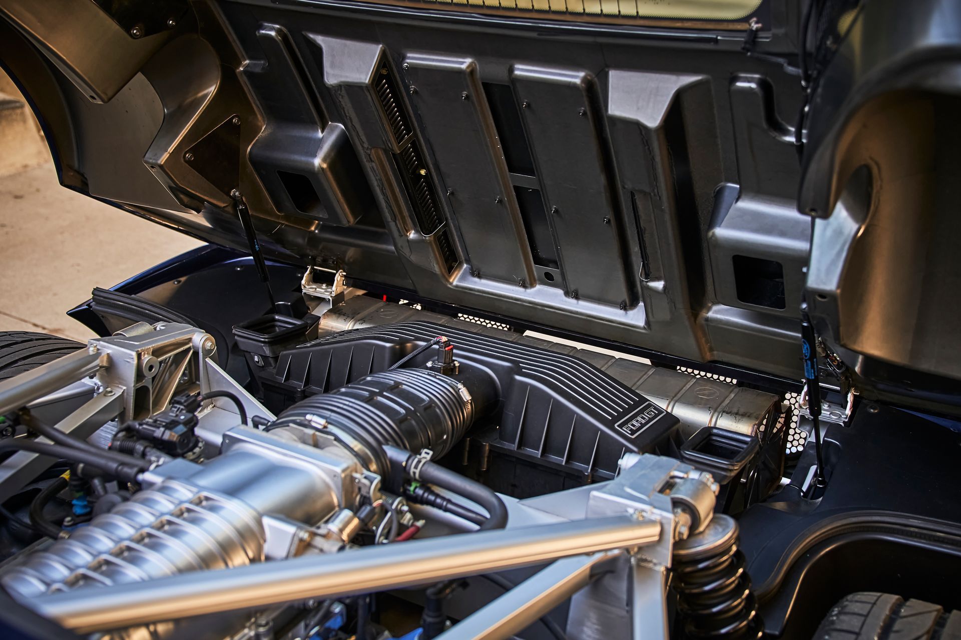 A close up of a car engine with the hood open.