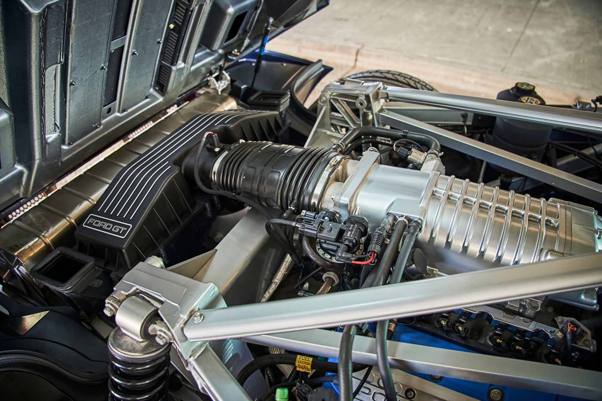 A close up of a car engine with the hood open