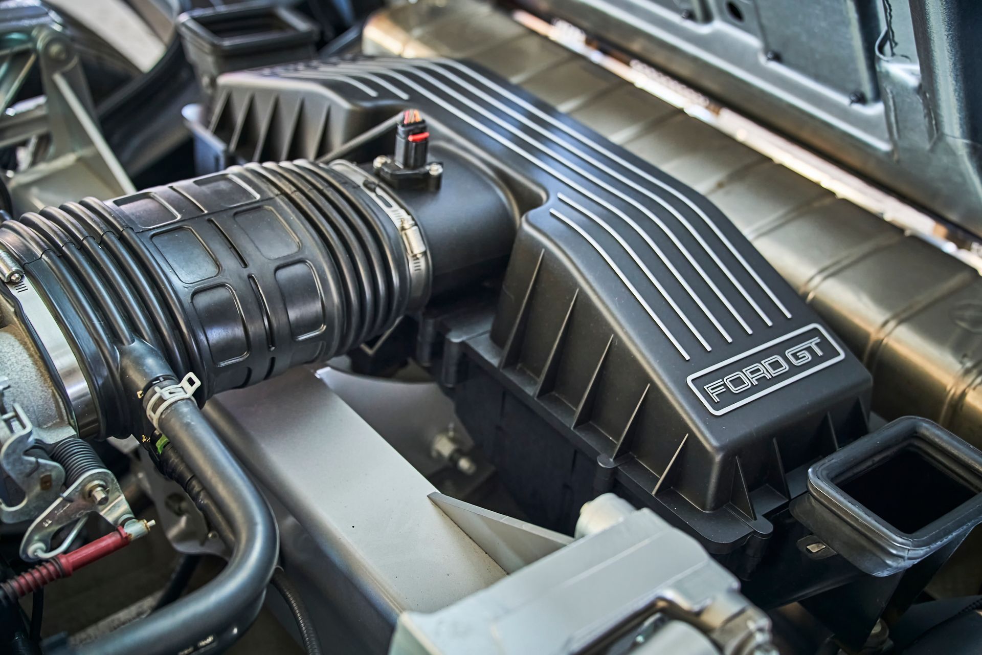 A close up of a ford gt engine with the hood open