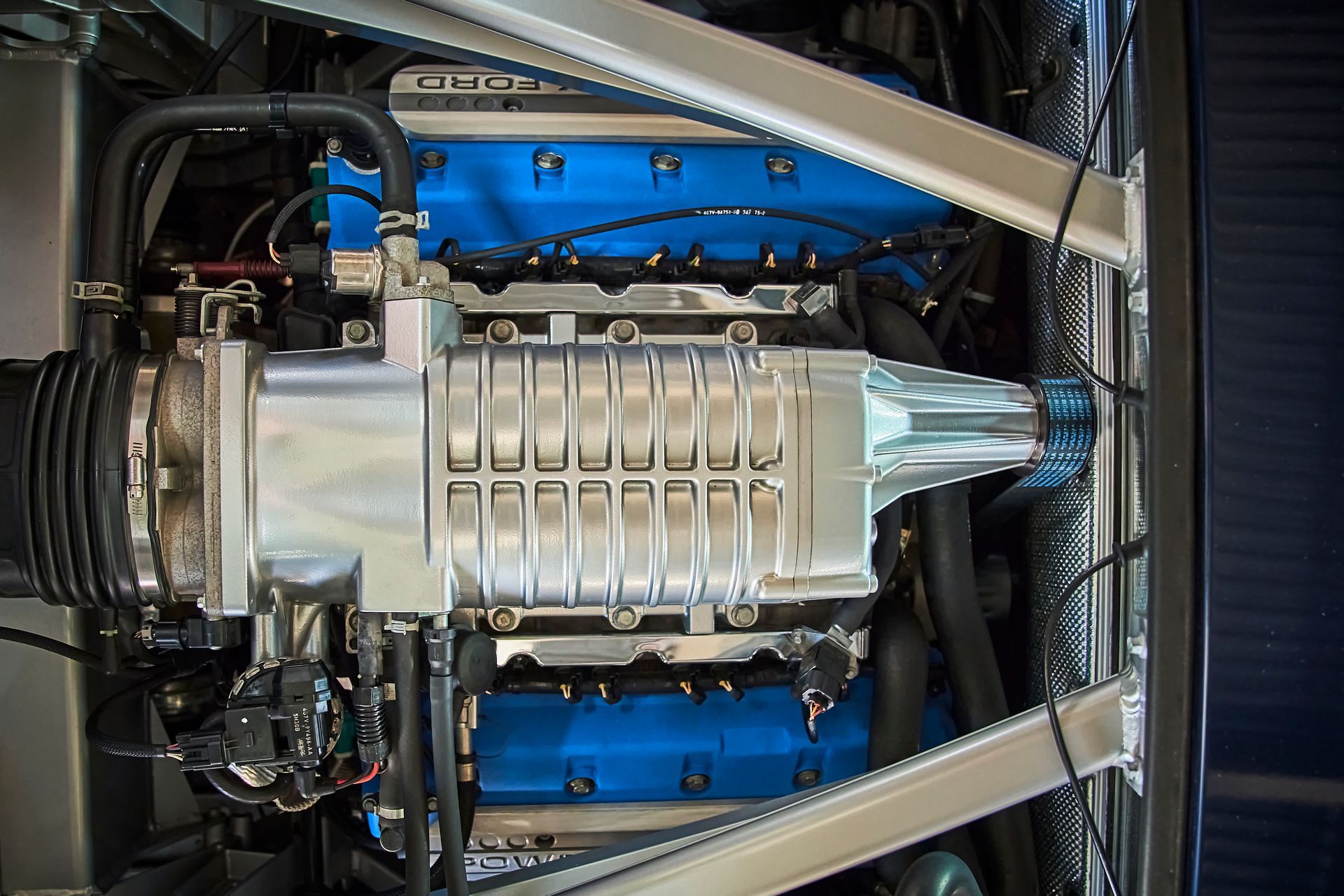 A close up of a car engine with blue valve covers