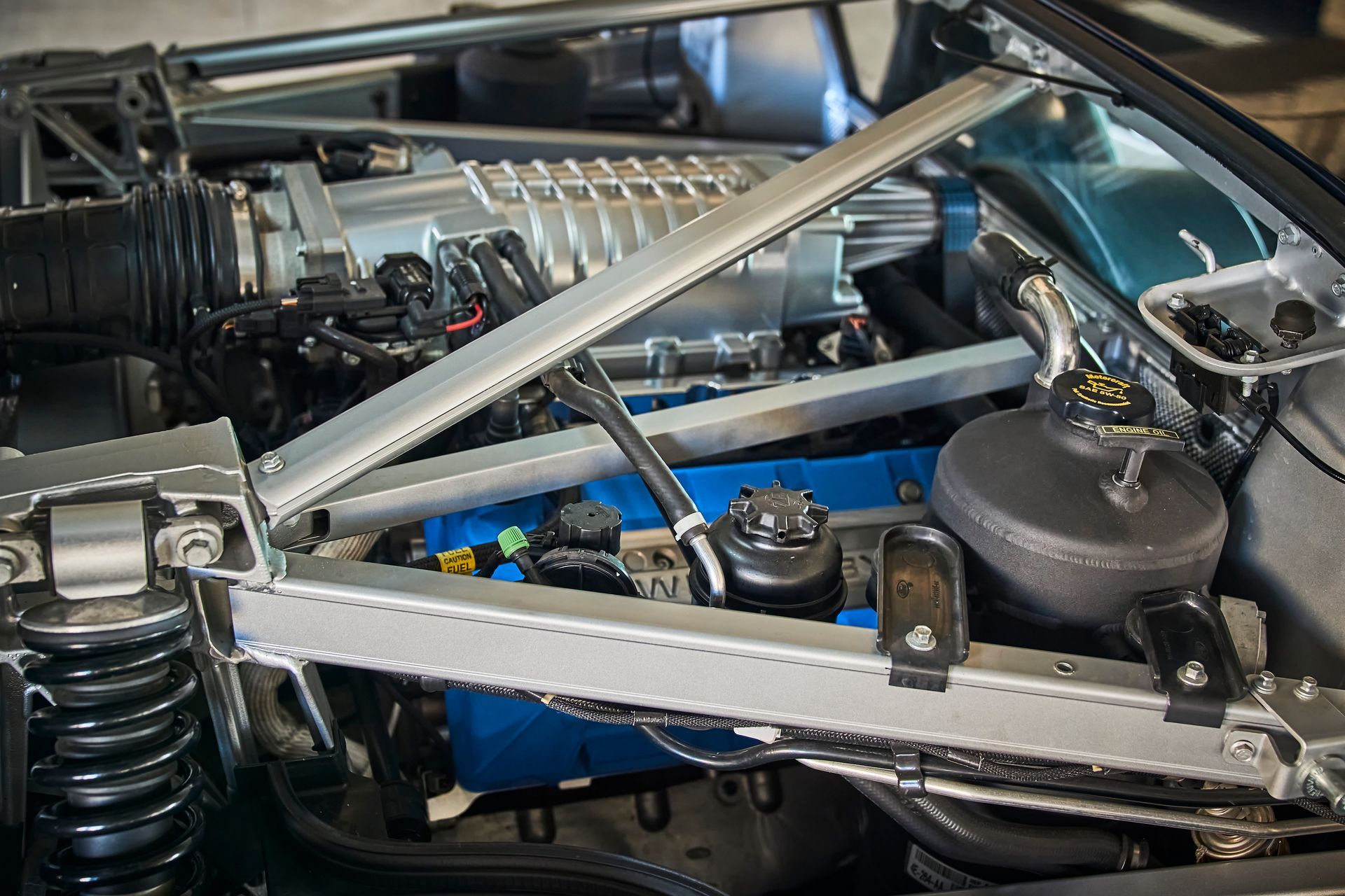 A close up of a car engine with the hood open.