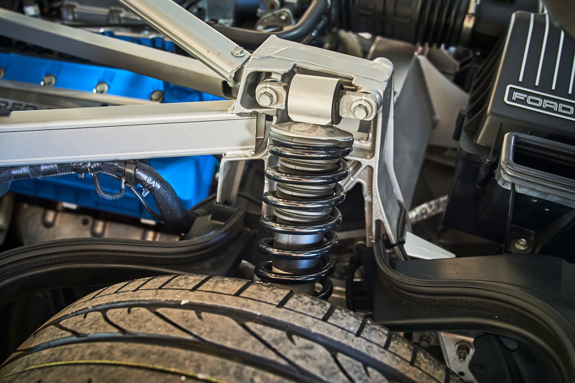 A close up of a car engine with a shock absorber and a tire.