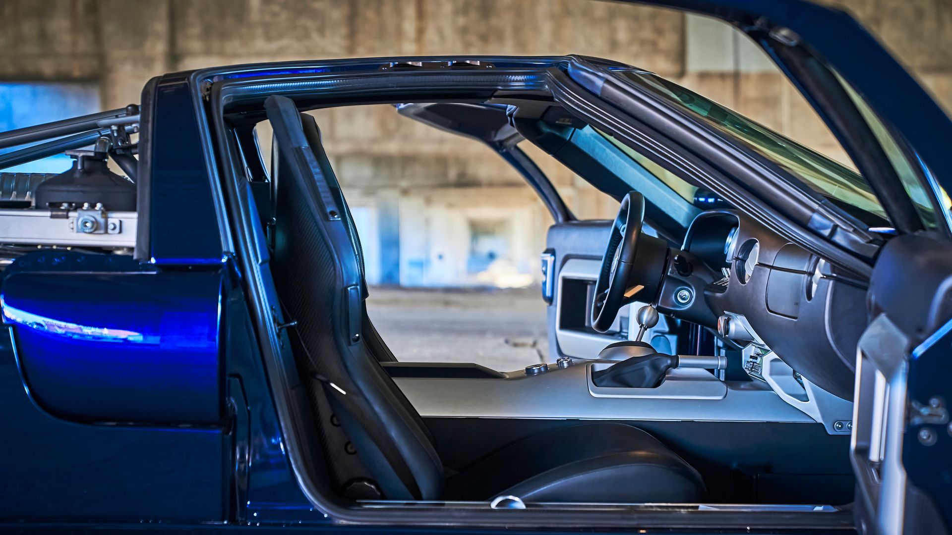 The inside of a blue sports car with the door open.