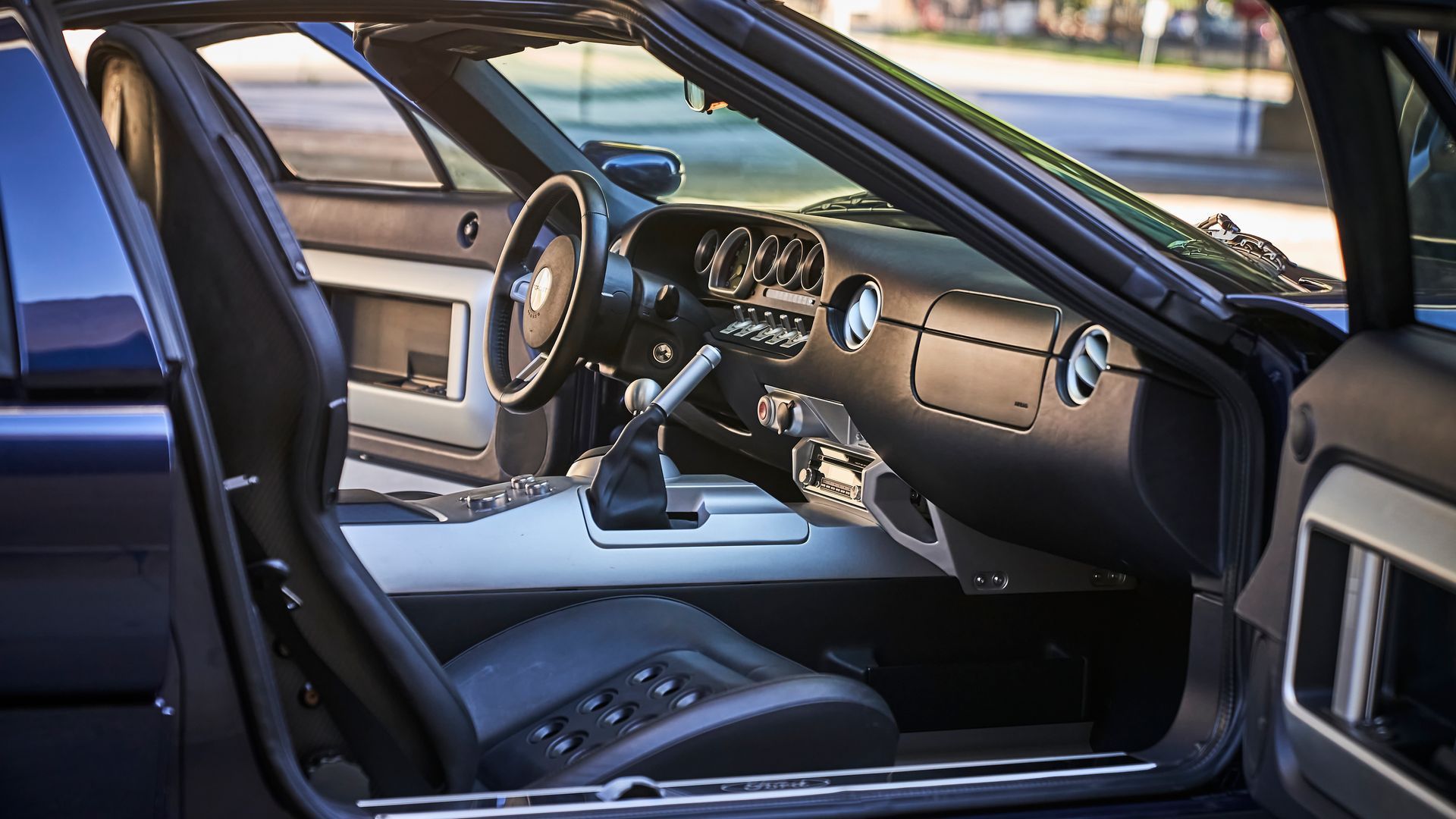The interior of a blue sports car with the door open