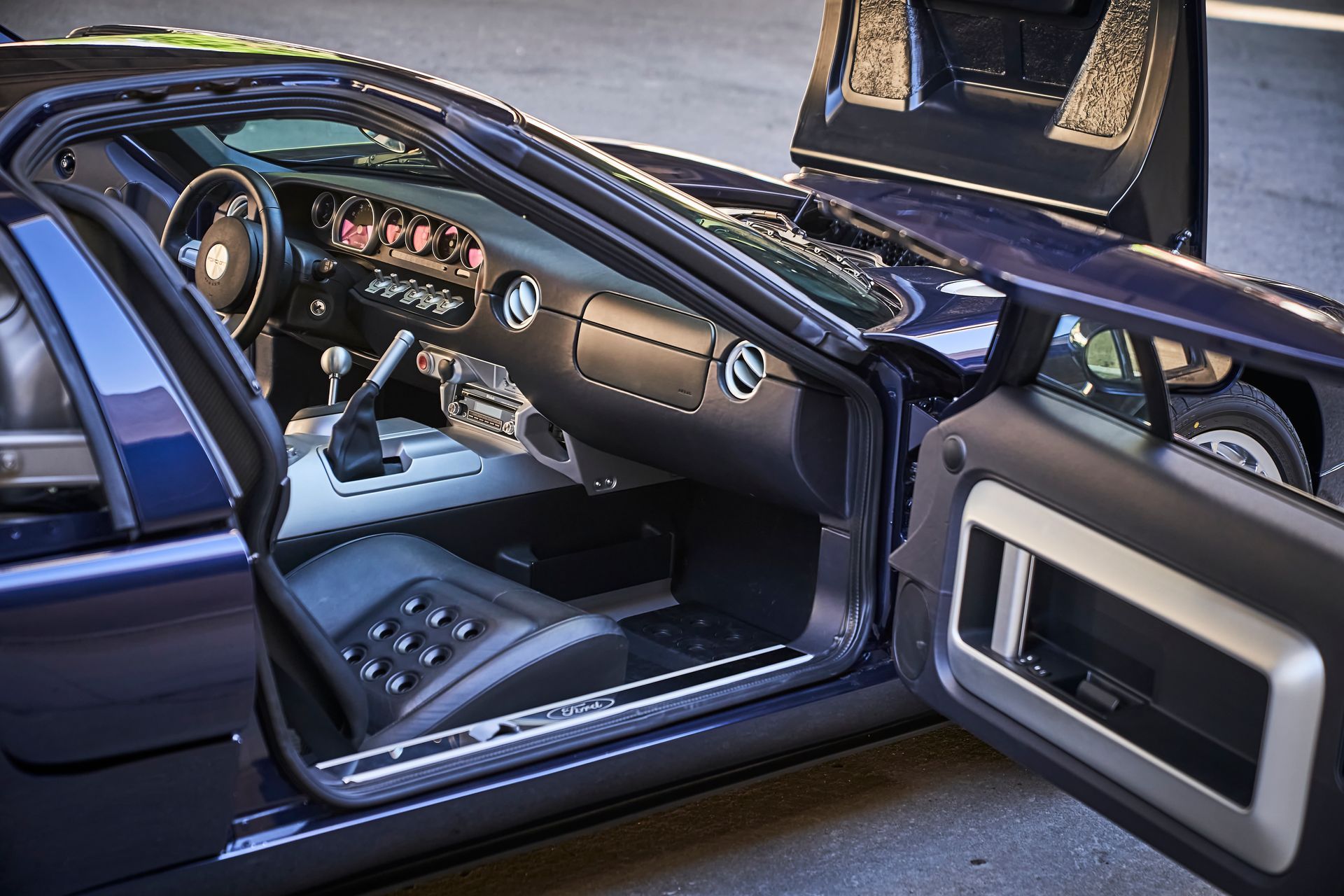 The inside of a blue sports car with the door open