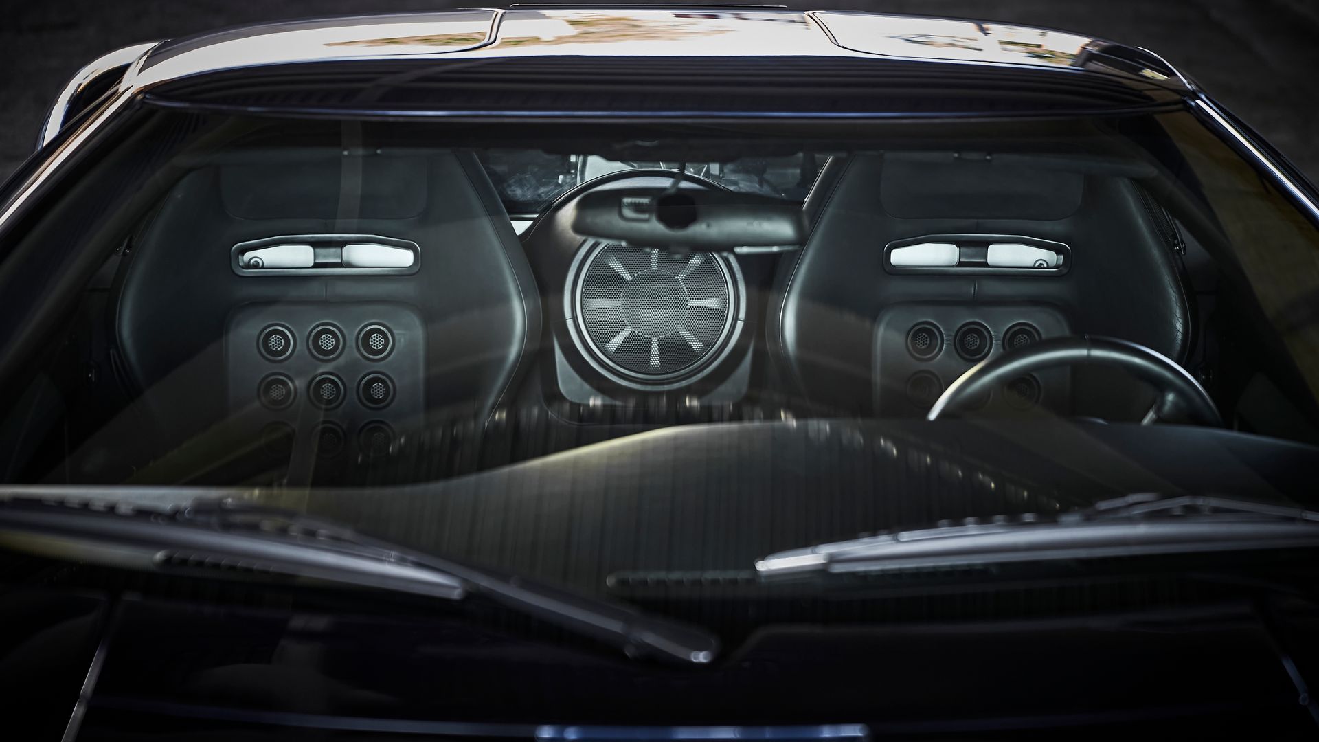 The inside of a car with a steering wheel and a windshield
