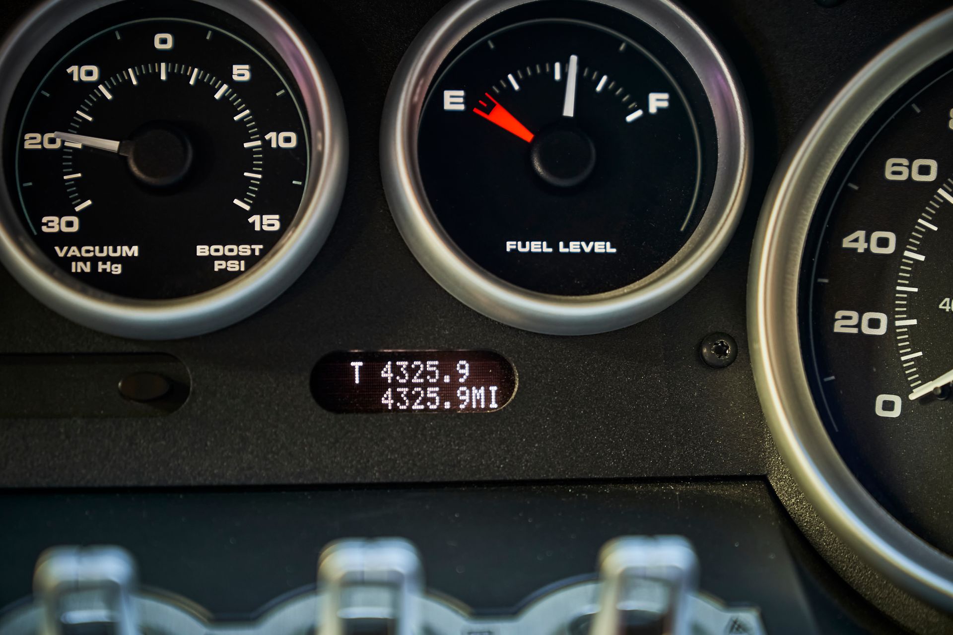 A close up of a car dashboard with a fuel level gauge
